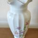 Porcelain vase with floral decoration and gold trim.