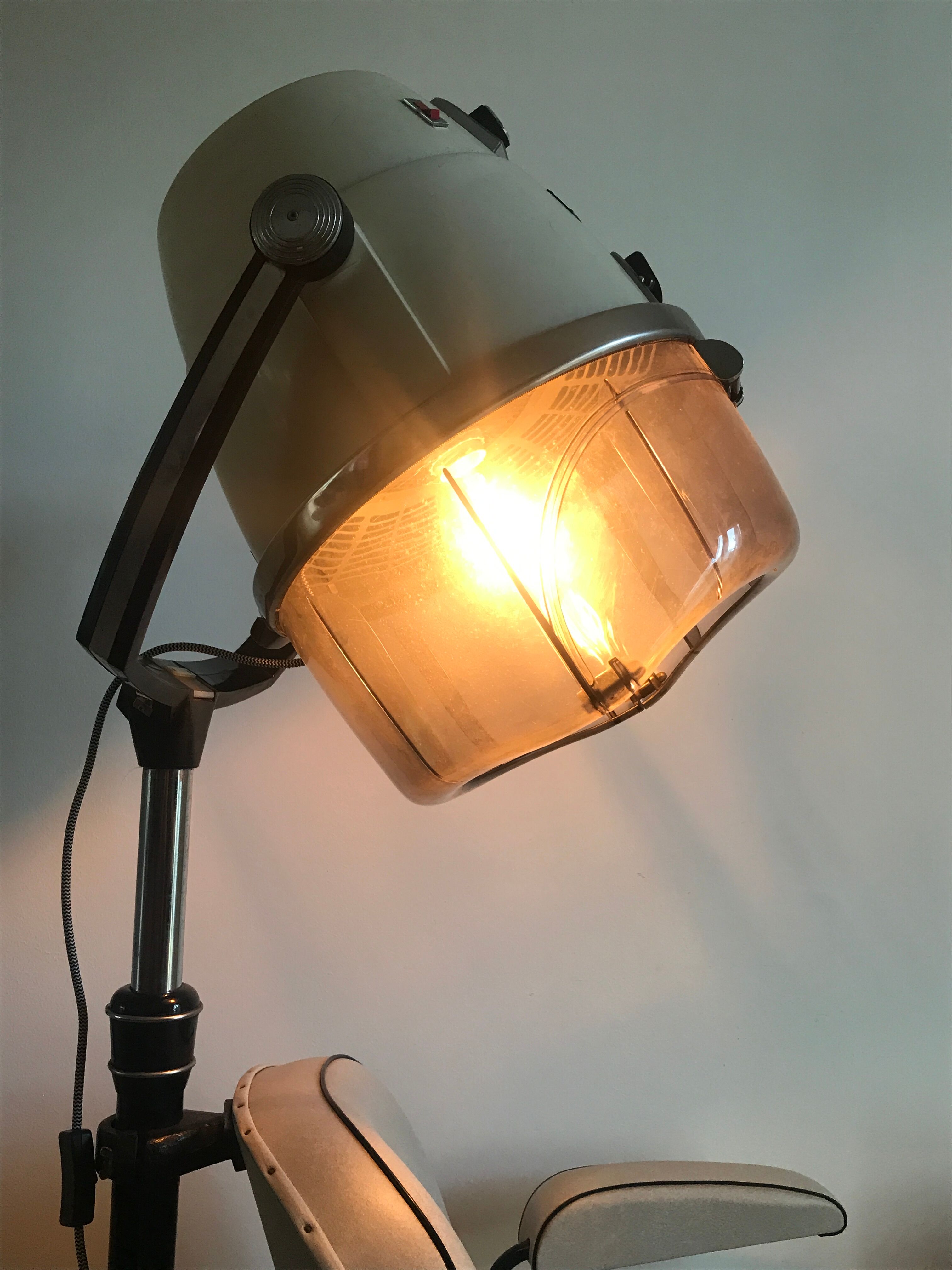 Vintage hairdresser's armchair with helmet transformed into a lamp