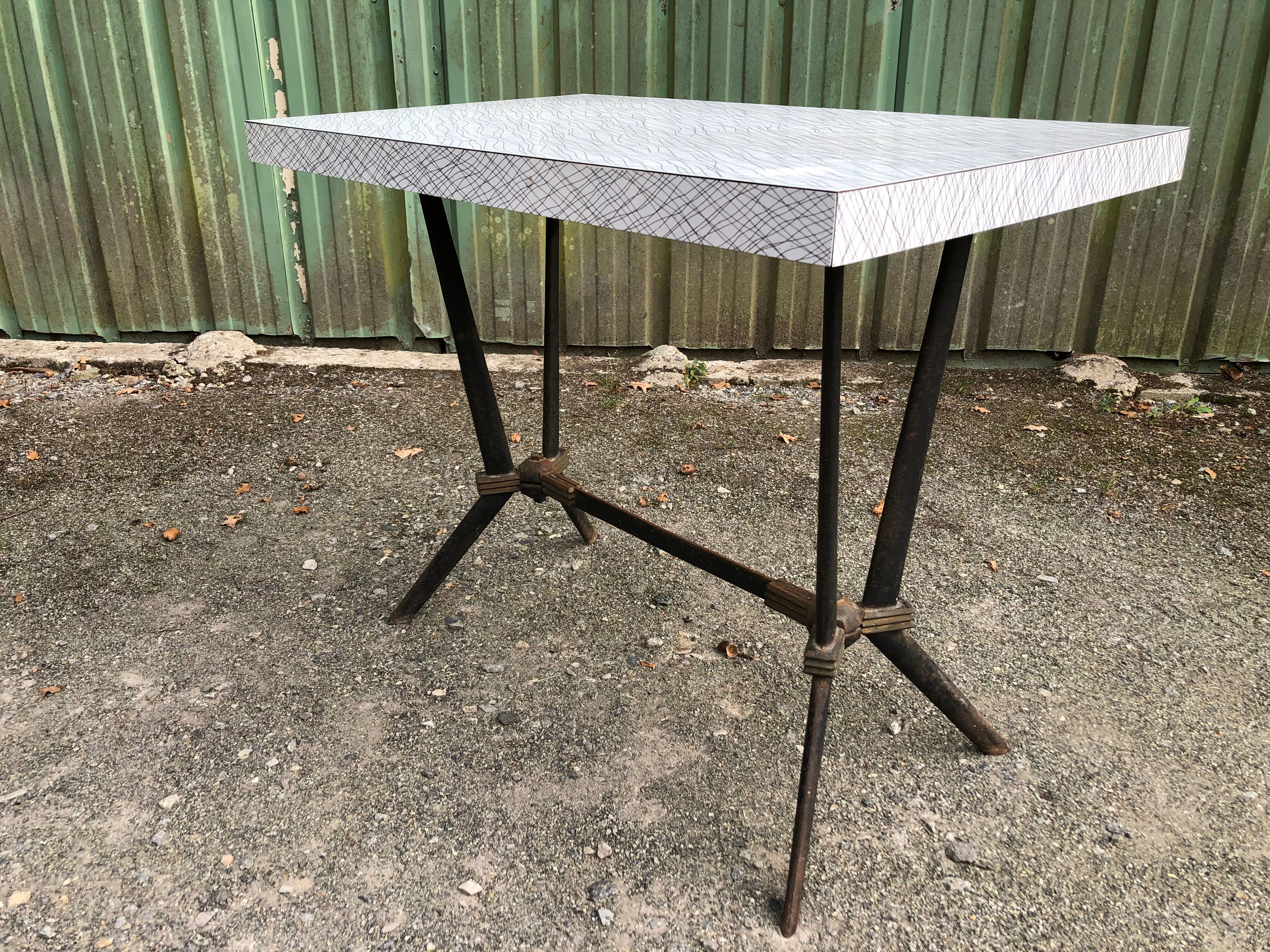 Vintage bistro table with an Art Deco style cast iron base and Formica top.