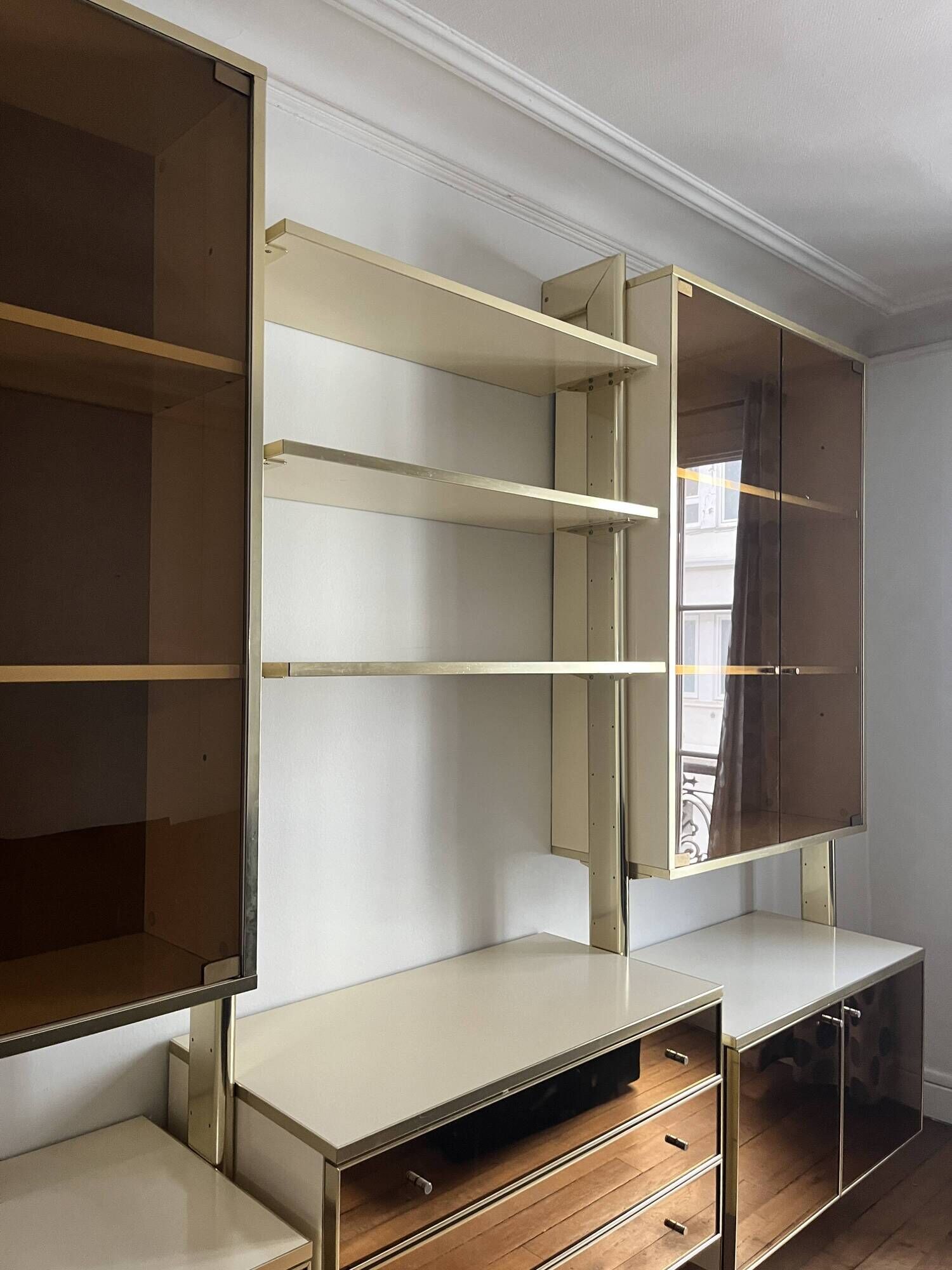 Wall-mounted and modular bookcase in lacquered brass, mirrors and smoked glass by Mahey, Design 1970