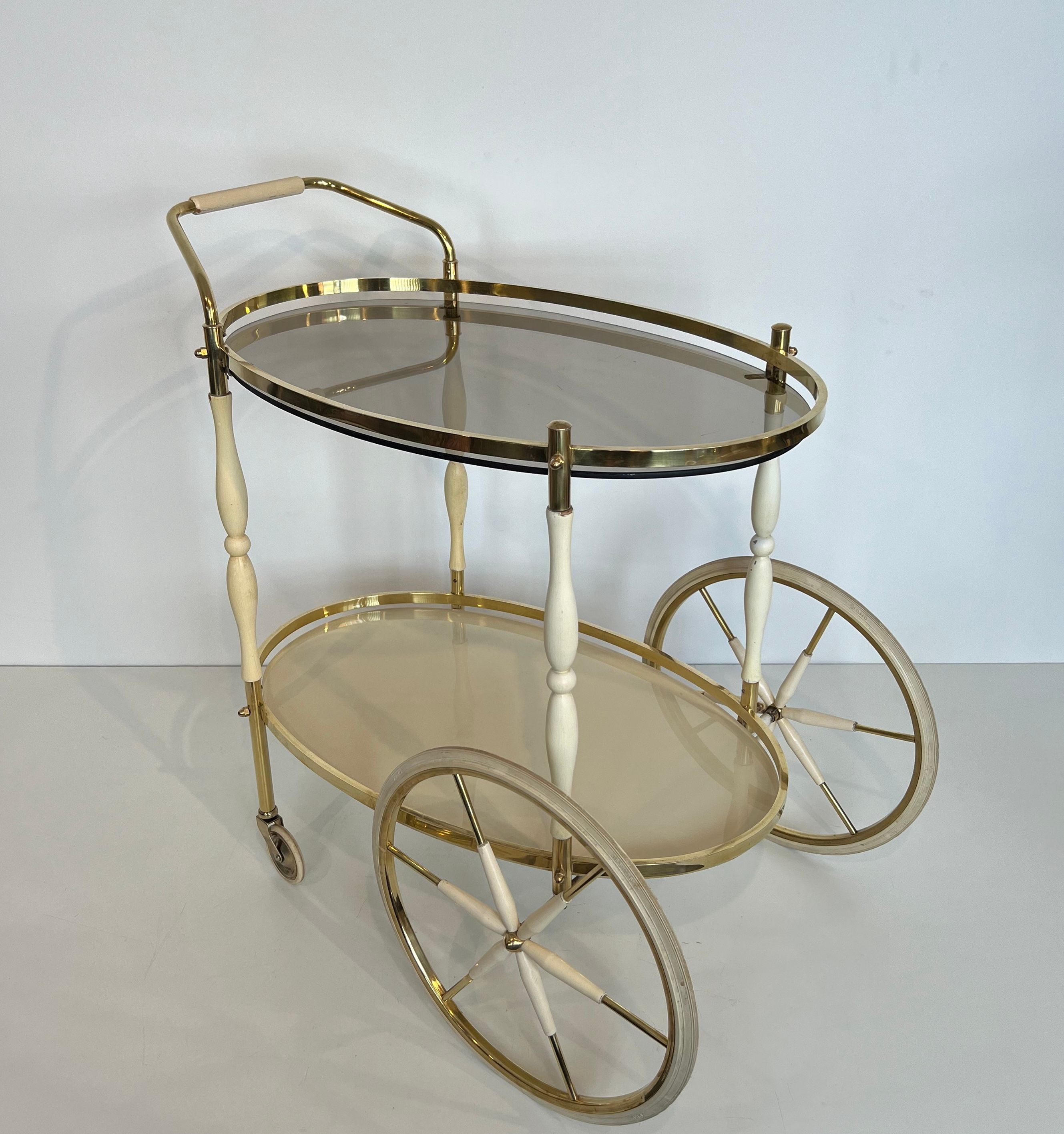 Italian oval rolling table in brass and lacquered wood.