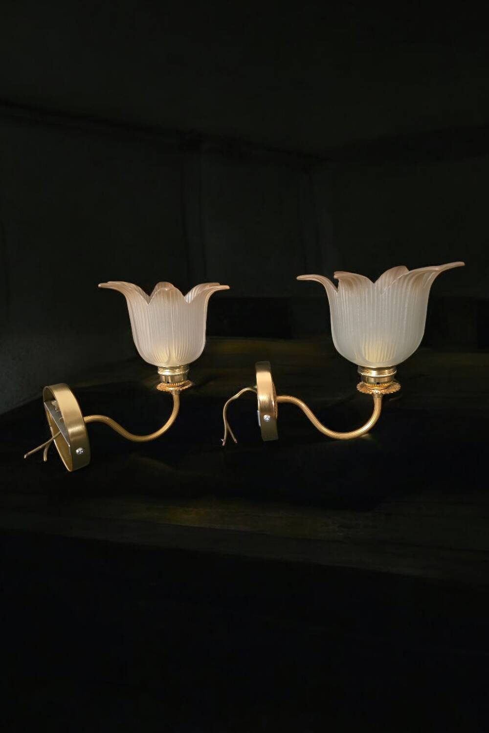 Frosted glass wall sconces and gilded brass in Art Deco style.