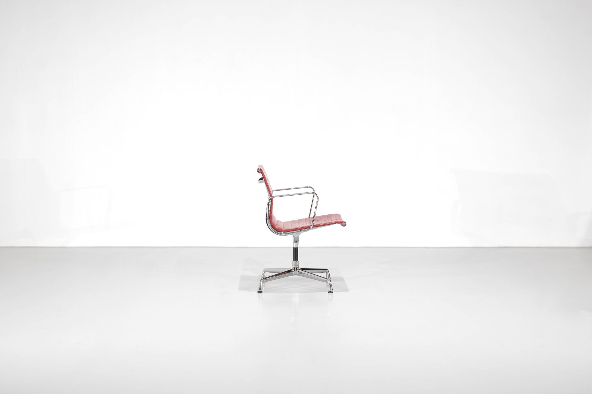 Fauteuil " EA 108 " en cuir rouge, conçu par Charles Ray Eames pour Vitra,
