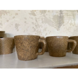 Set of stoneware coffee cups with saucers.