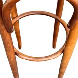 Old high stool in curved wood with caned seat