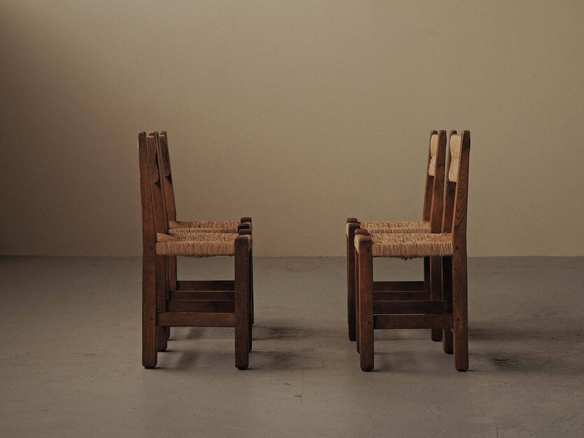 Set of four modernist chairs in oak and straw, France, circa 1960.
