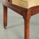 Chaise d'appoint avec un cadre en bois et un revêtement en tissu jaune.