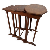 Four nesting tables with polygonal tops and decorative inlays.