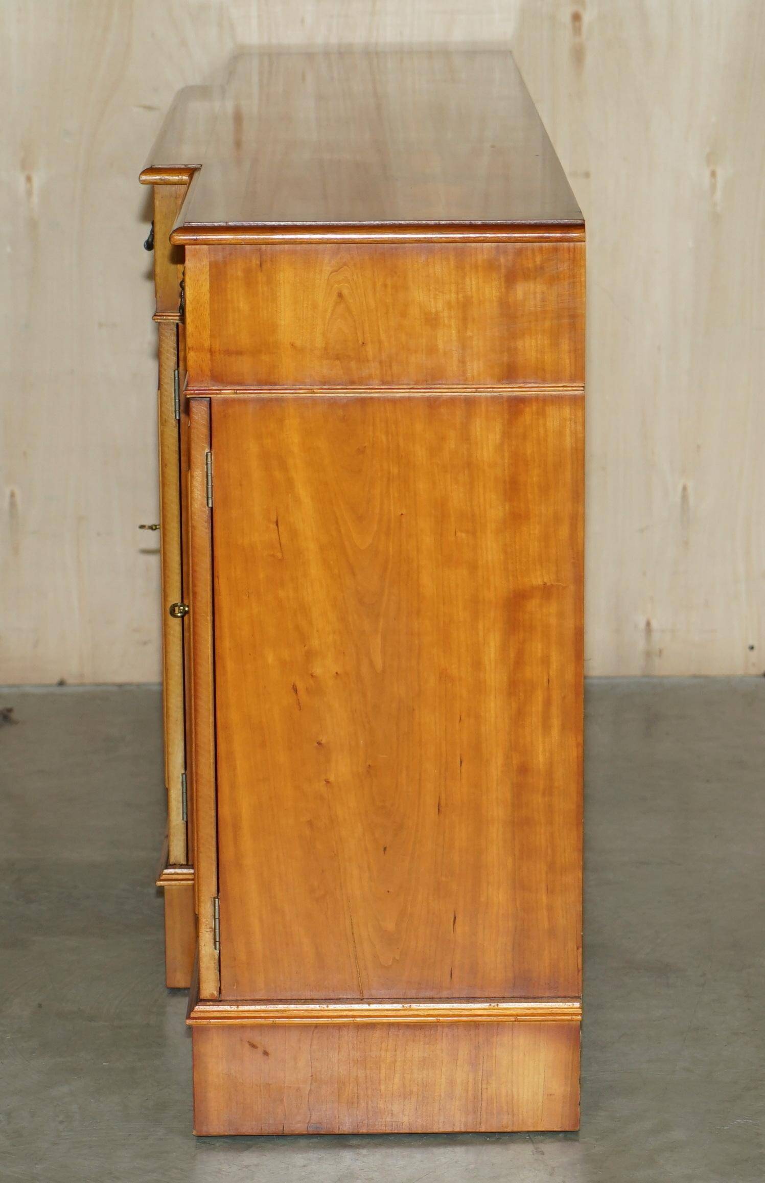 Vintage buffet made of mottled yew wood with three doors and four drawers.