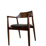 Curved wooden dining chair with brown leather seat
