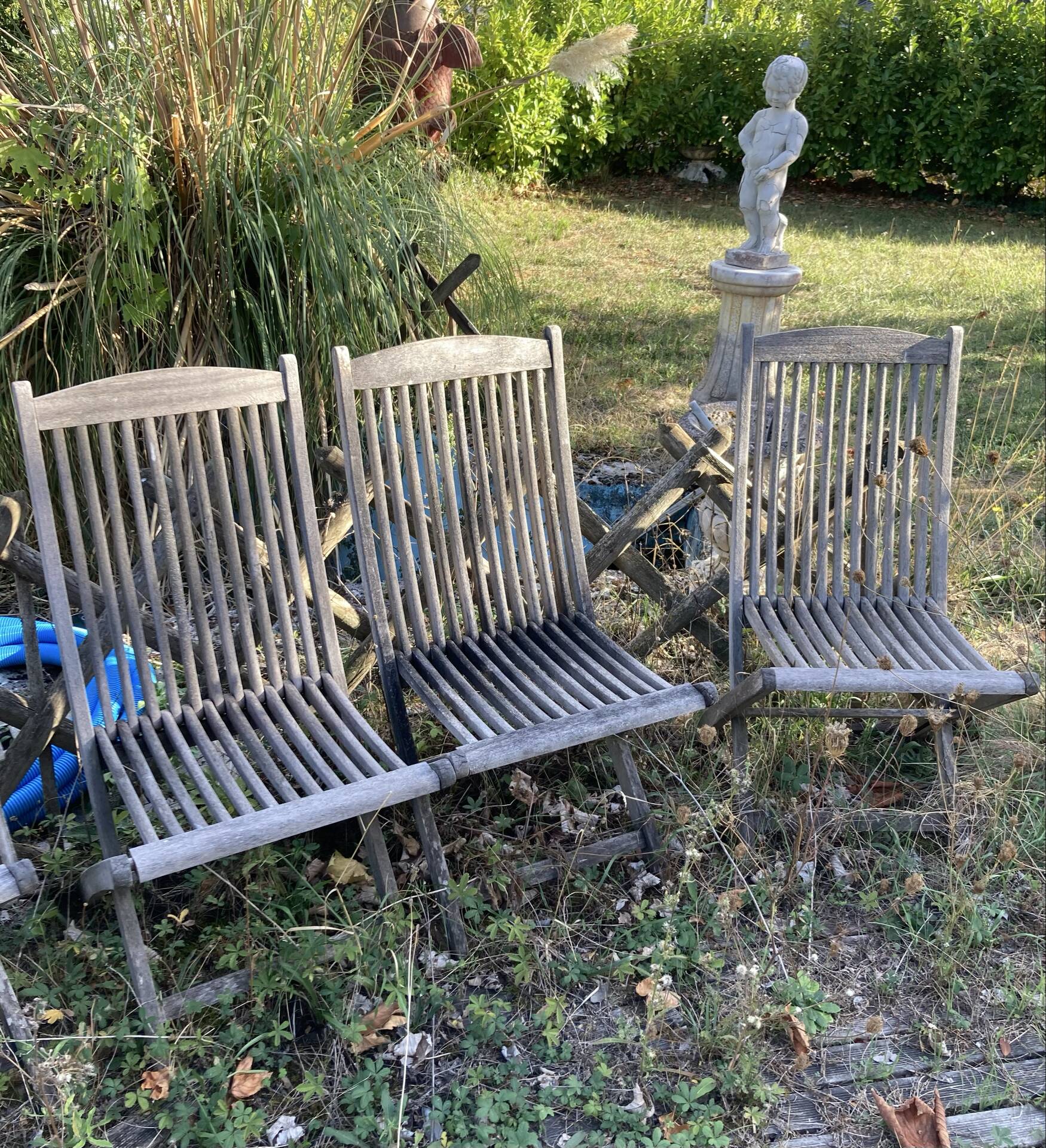 Folding garden chairs and armchairs in River Han dowelled teak.
