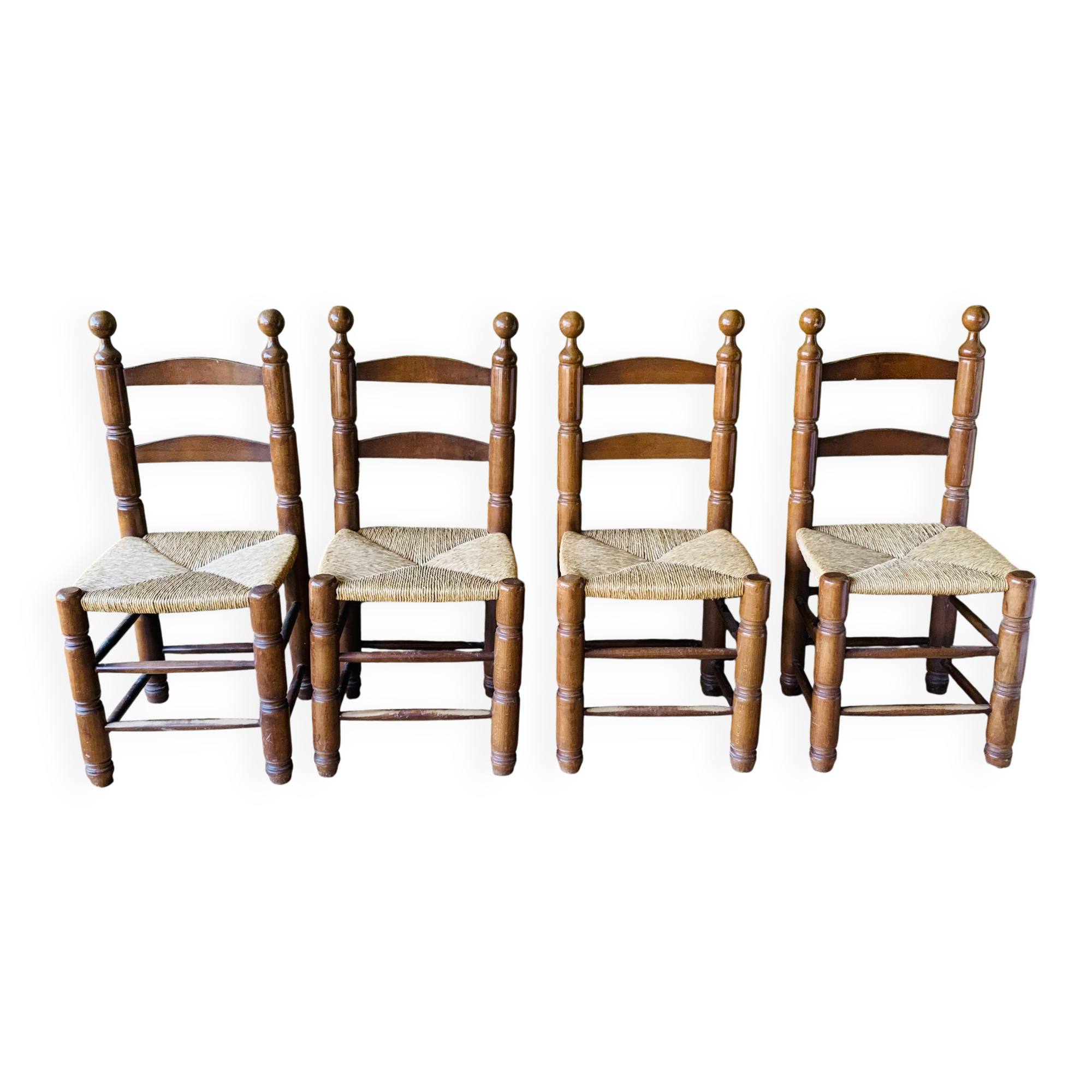 Set of 4 solid wood chairs with straw seats.
