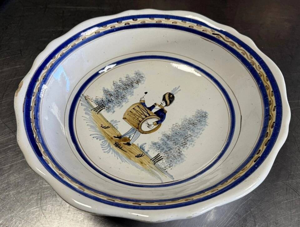 Large earthenware centerpiece dish with painted decoration of a drummer