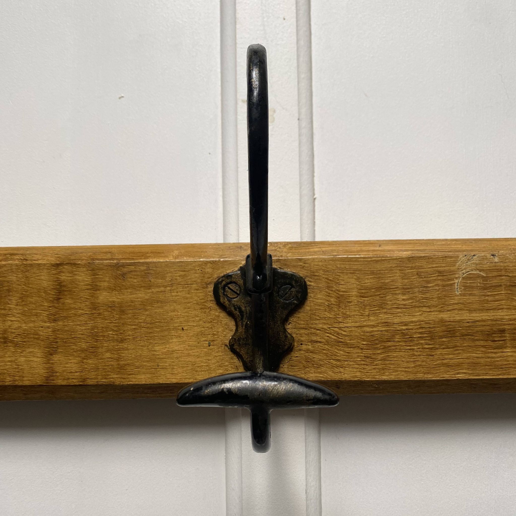 Antique wooden coat rack with metal hooks