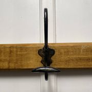 Antique wooden coat rack with metal hooks