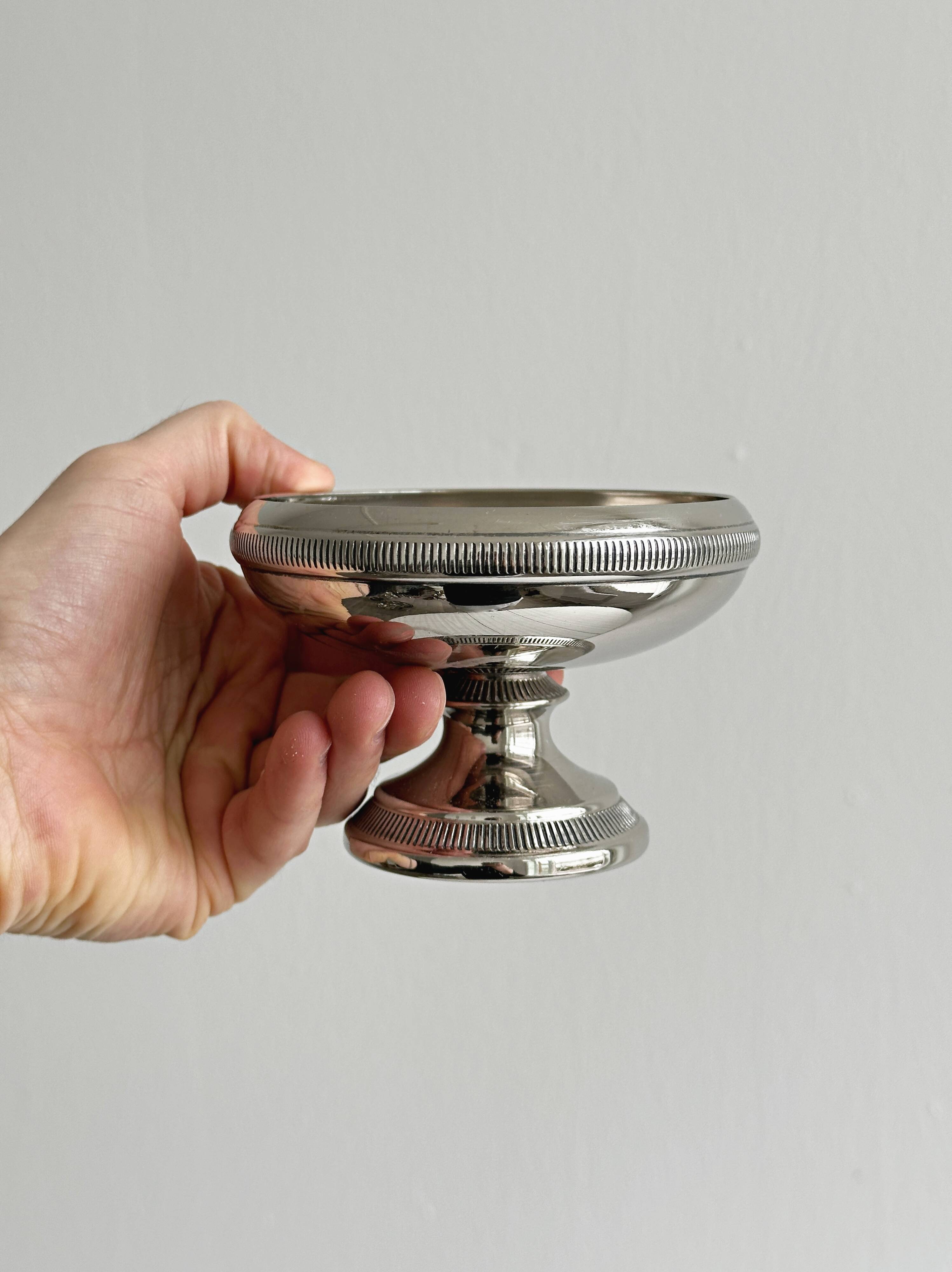 Small silver-plated metal bowl on a stand.