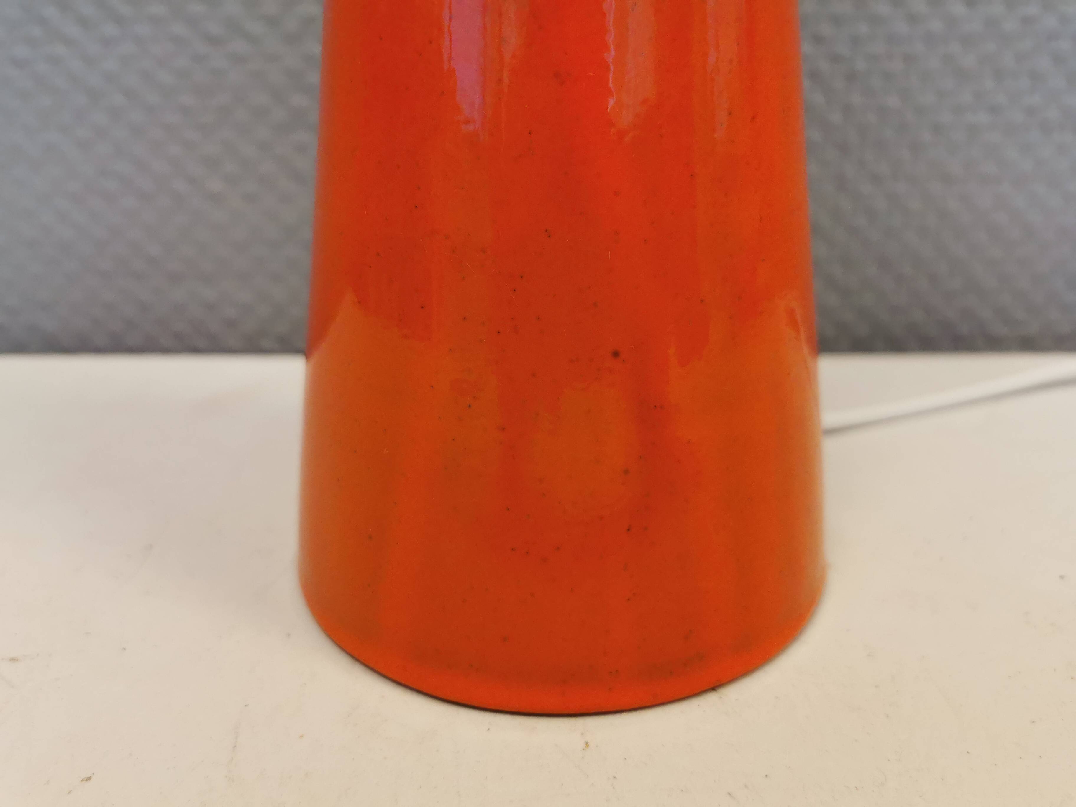 Ceramic table lamp with partial orange glaze.