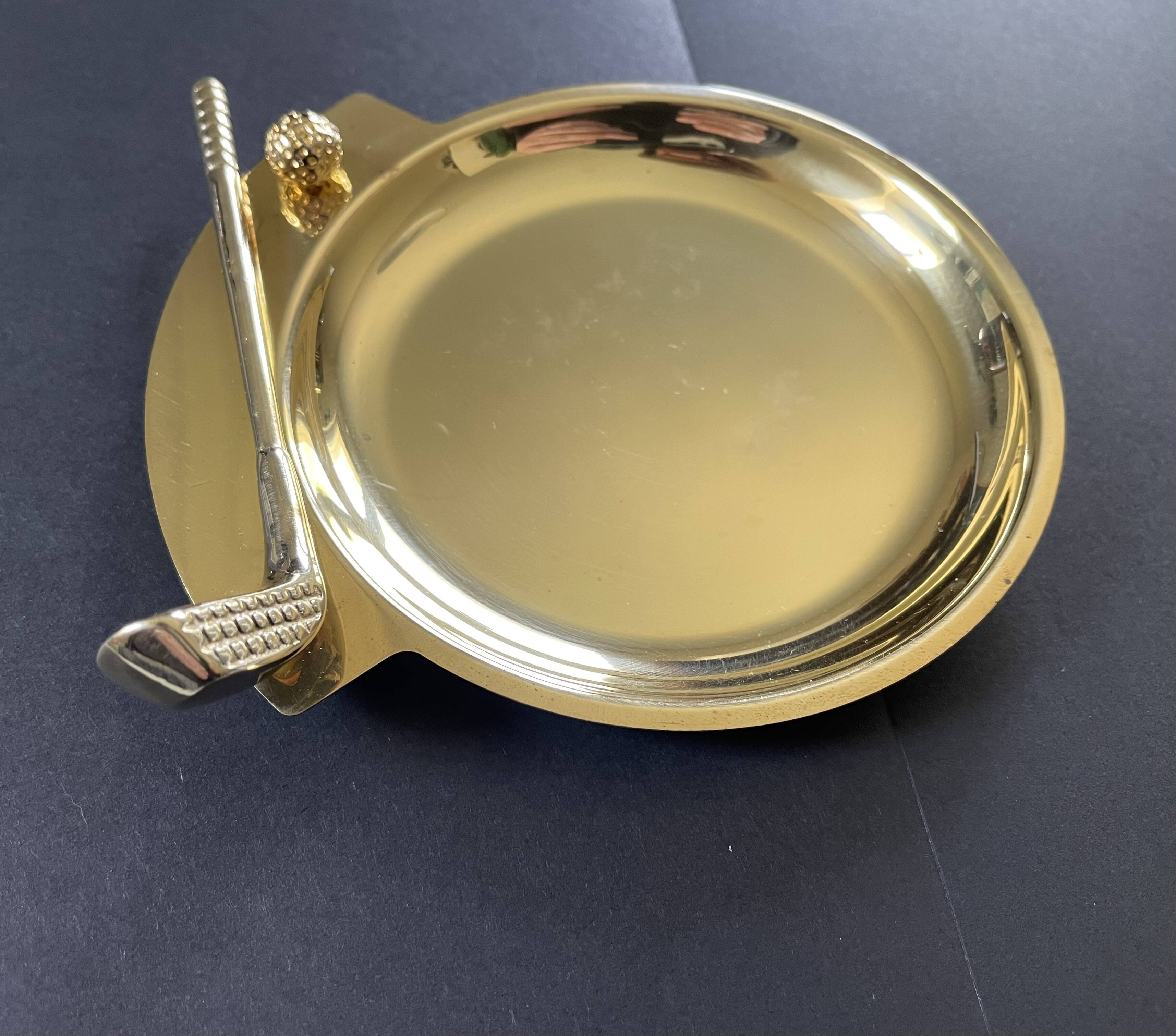 Round brass pocket tray with club and golf ball decoration.