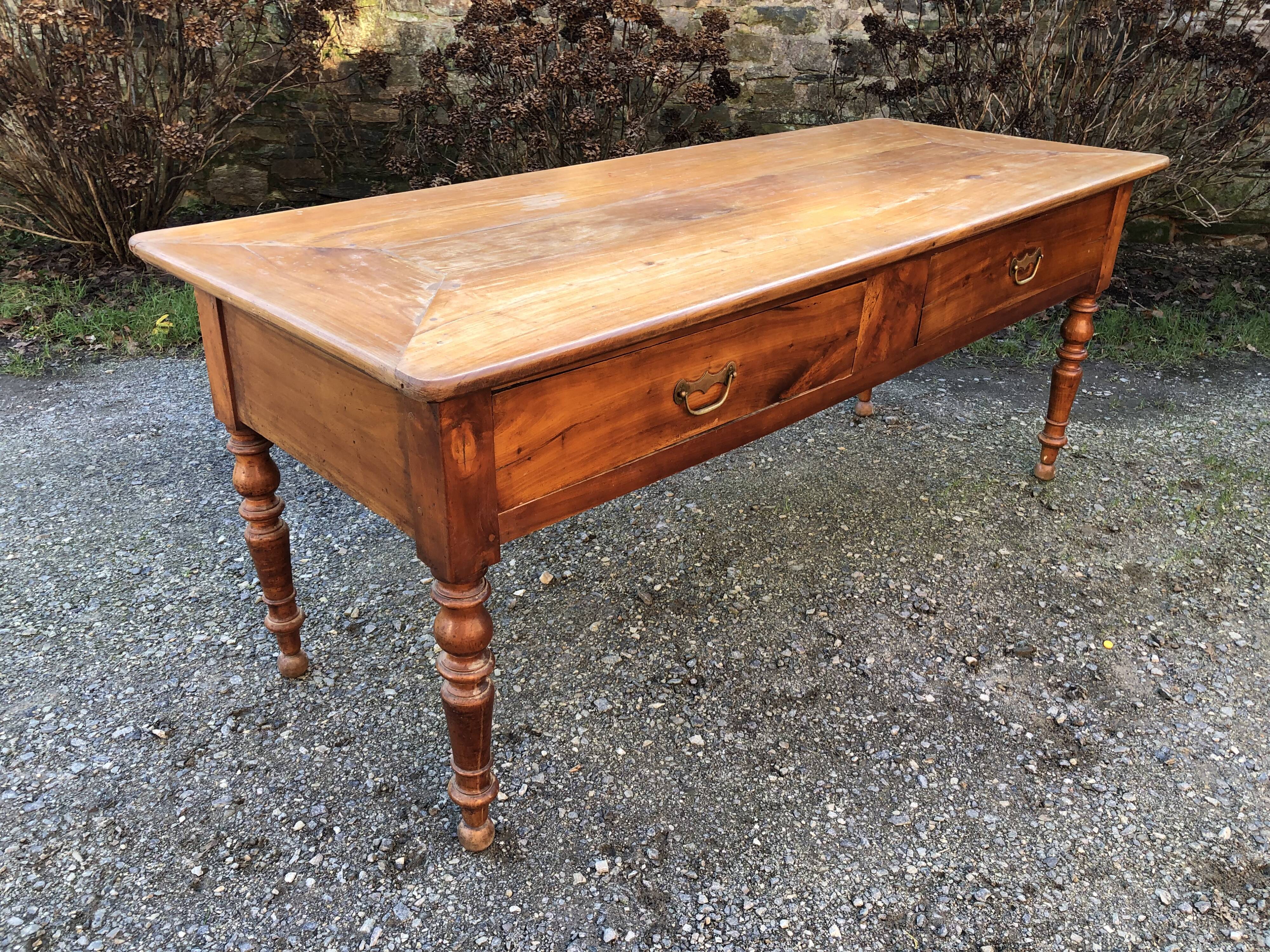 Antique cherry farmhouse table with turned legs and 2 drawers.