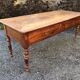 Antique cherry farmhouse table with turned legs and 2 drawers.