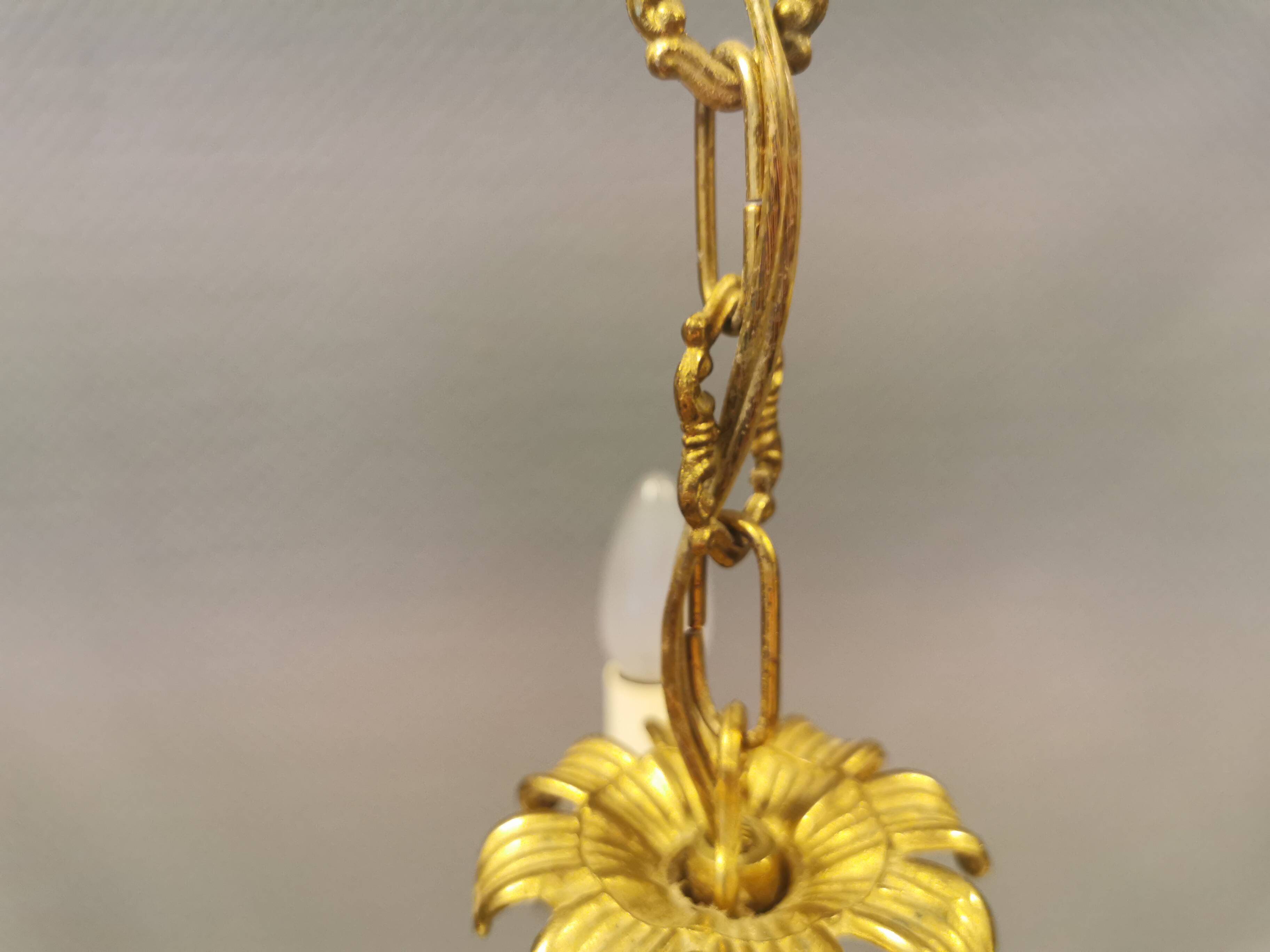 Older brass alloy chandelier with three light sources.