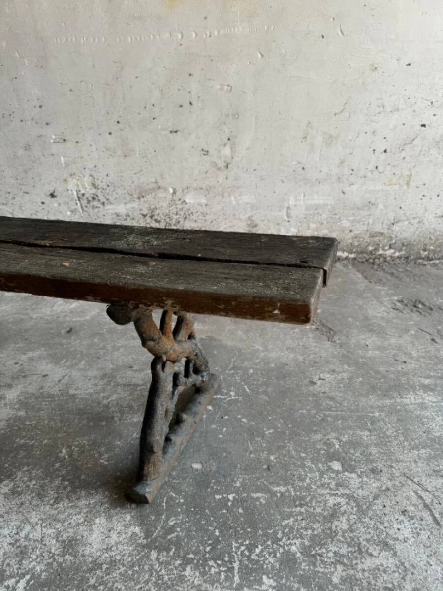 Dark brown wood and black cast-iron antique garden bench with weathered solid-wood seat