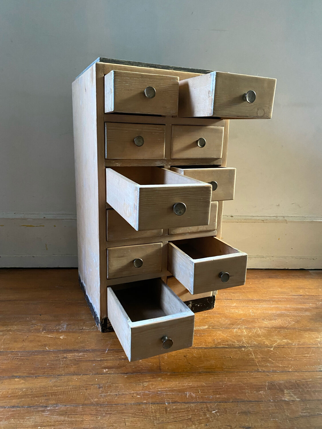 Vintage antique workshop cabinet with 12 drawers in raw wood.