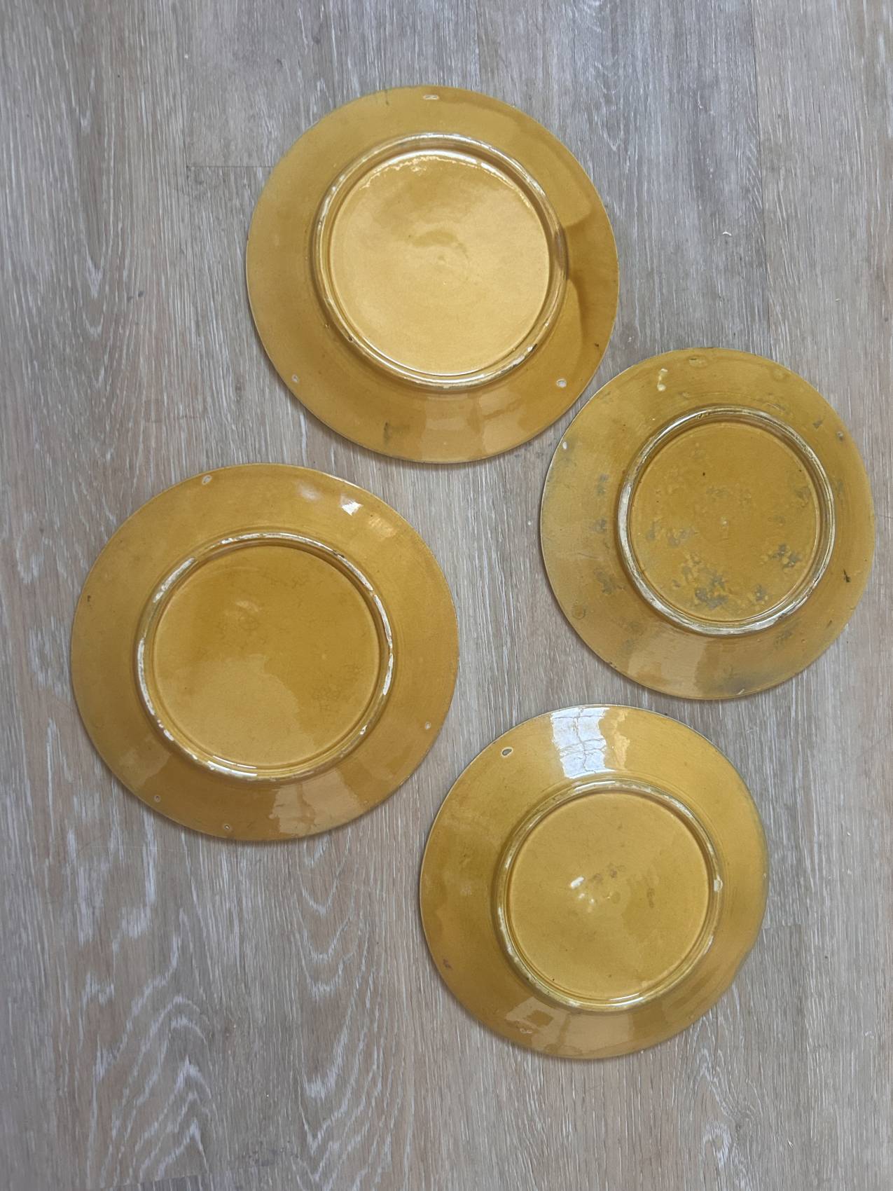 Four antique dessert plates in majolica with vine decoration.