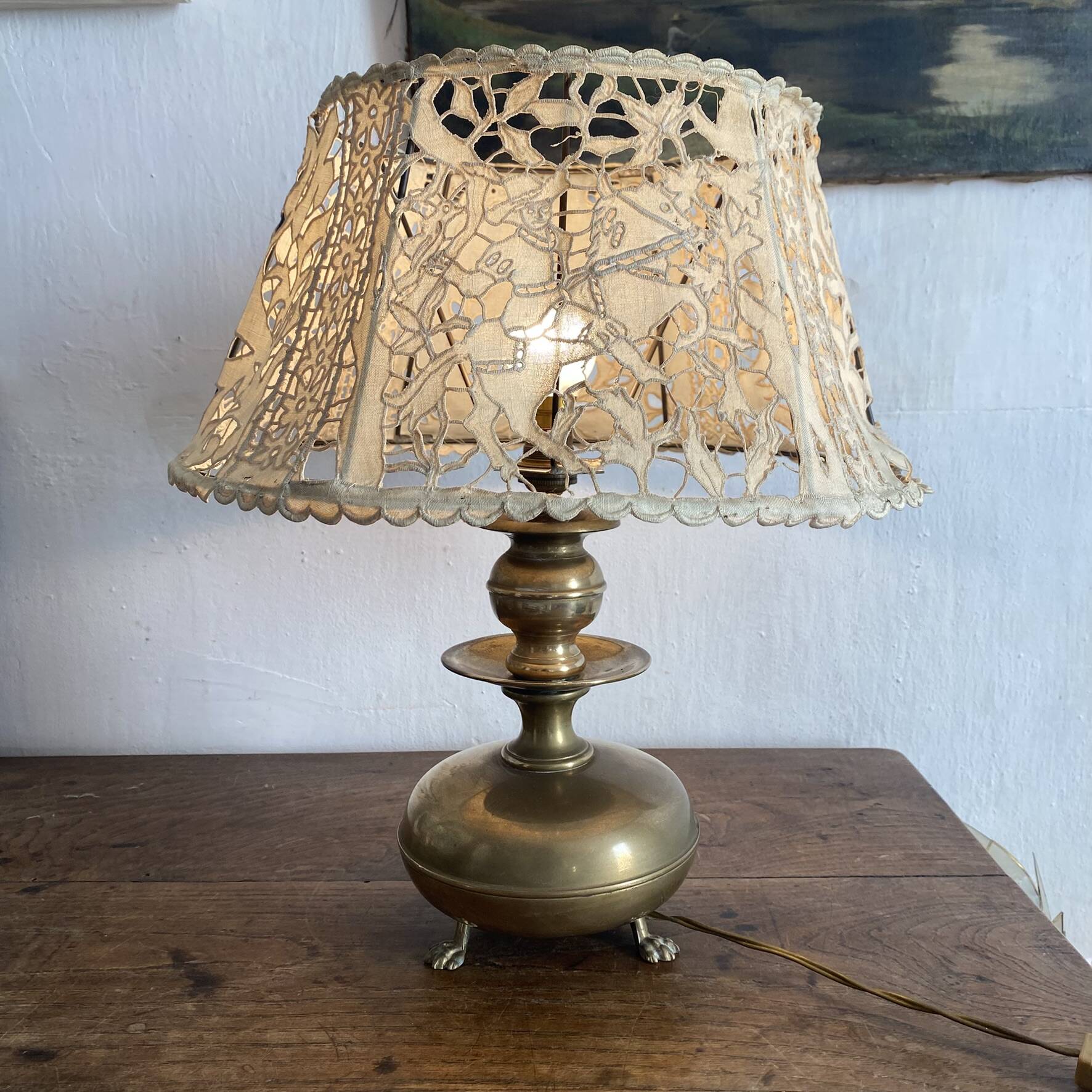 Antique brass lamp with embroidered openwork shade.
