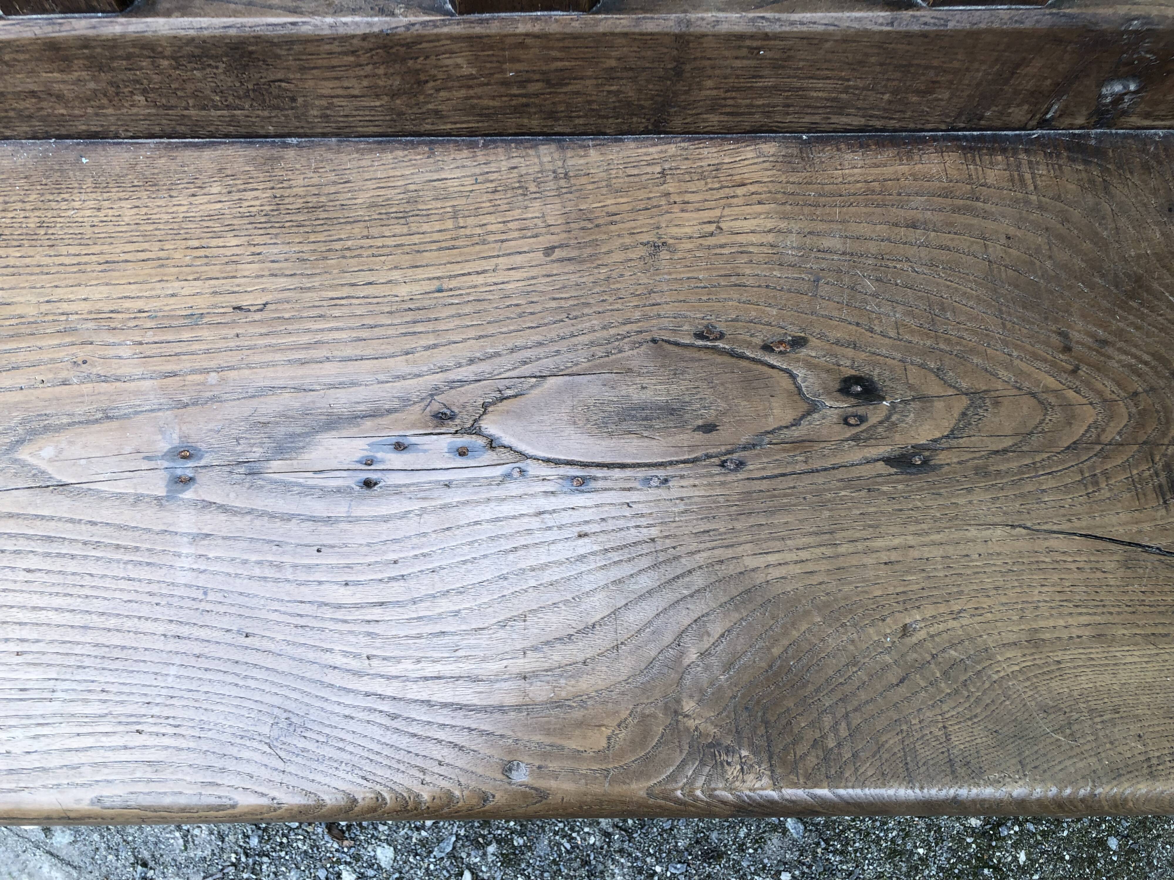 Duo of old solid oak benches with backs and armrests.