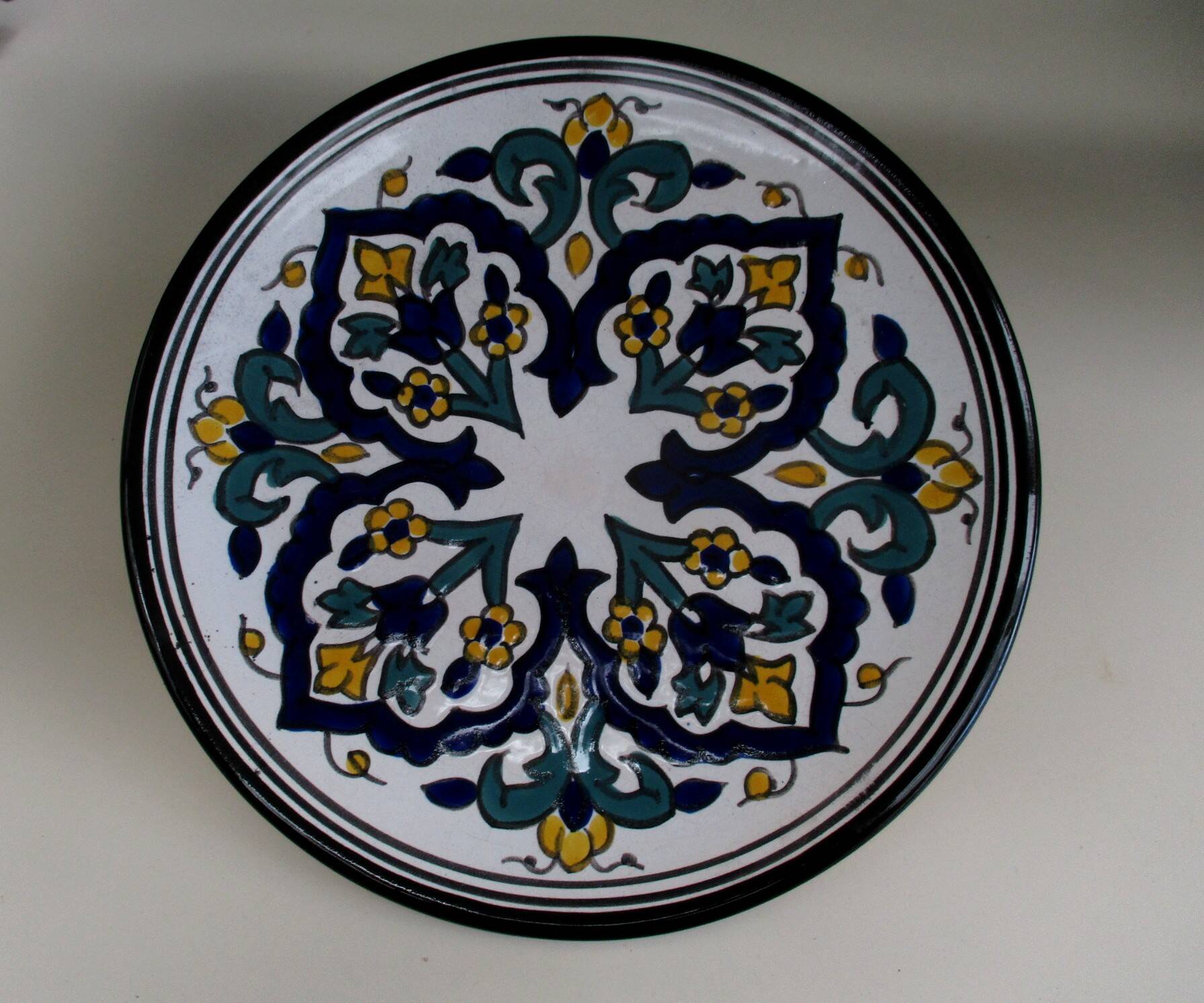 Round ceramic plate with hand-painted decoration
