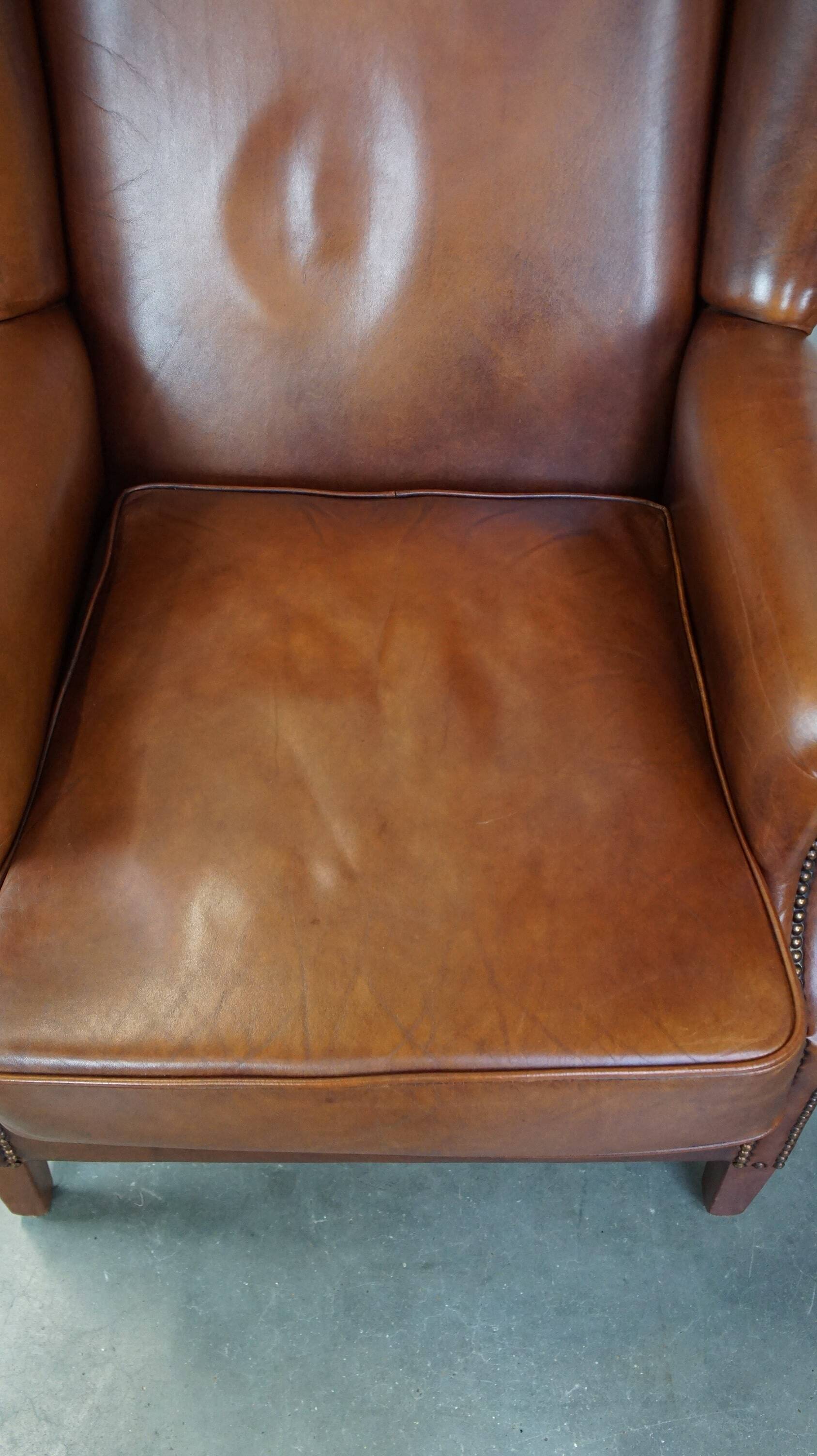 Fauteuil à oreilles en cuir de vachette cognac