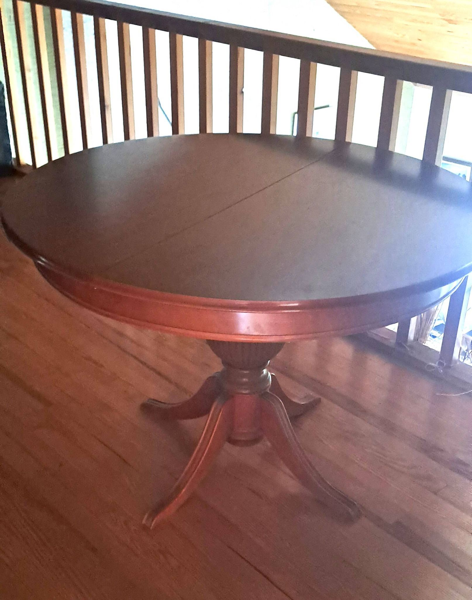 Round solid walnut table with central leg from the 1950s with extensions.