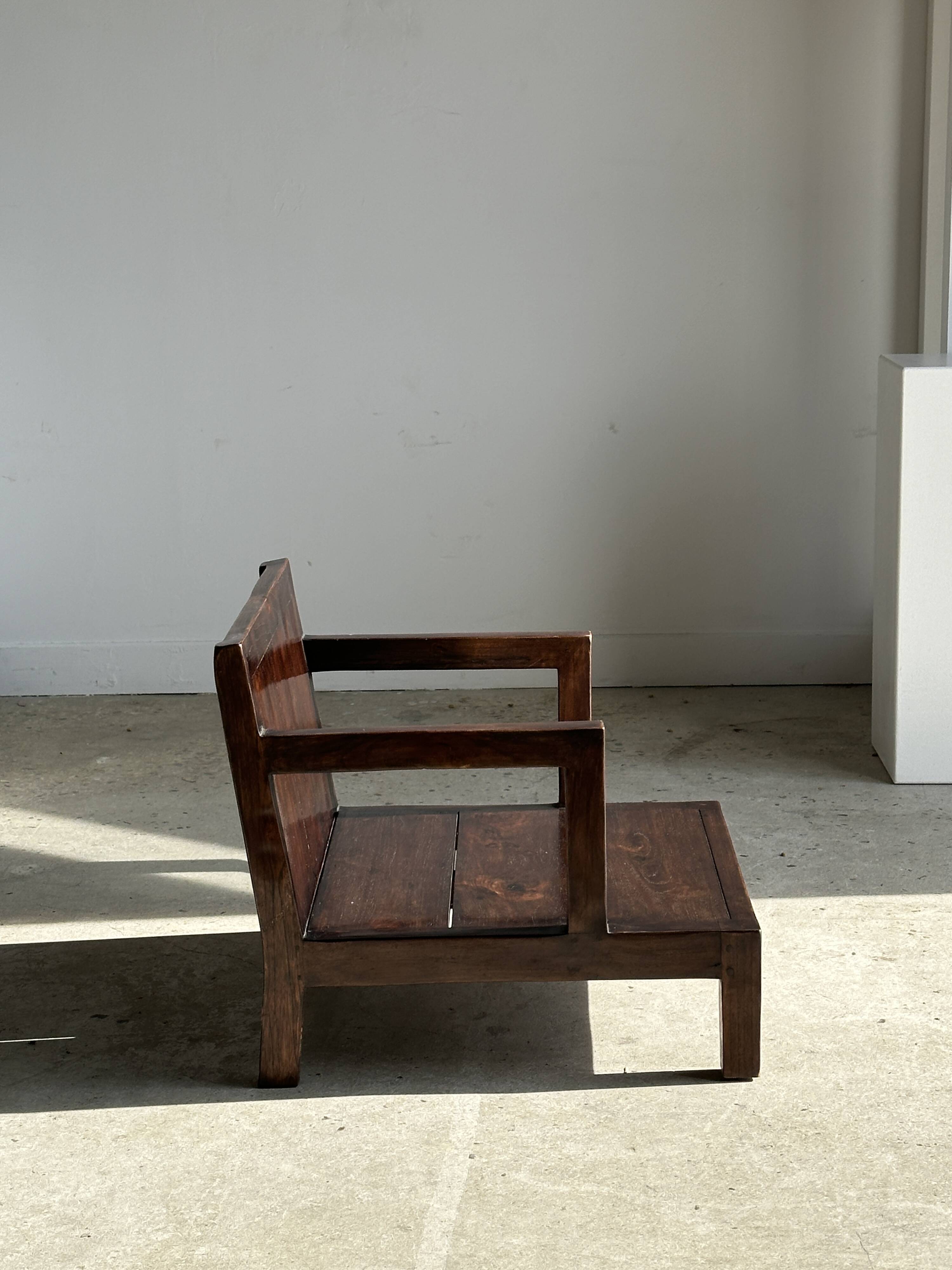 Small low armchair in varnished brown wood