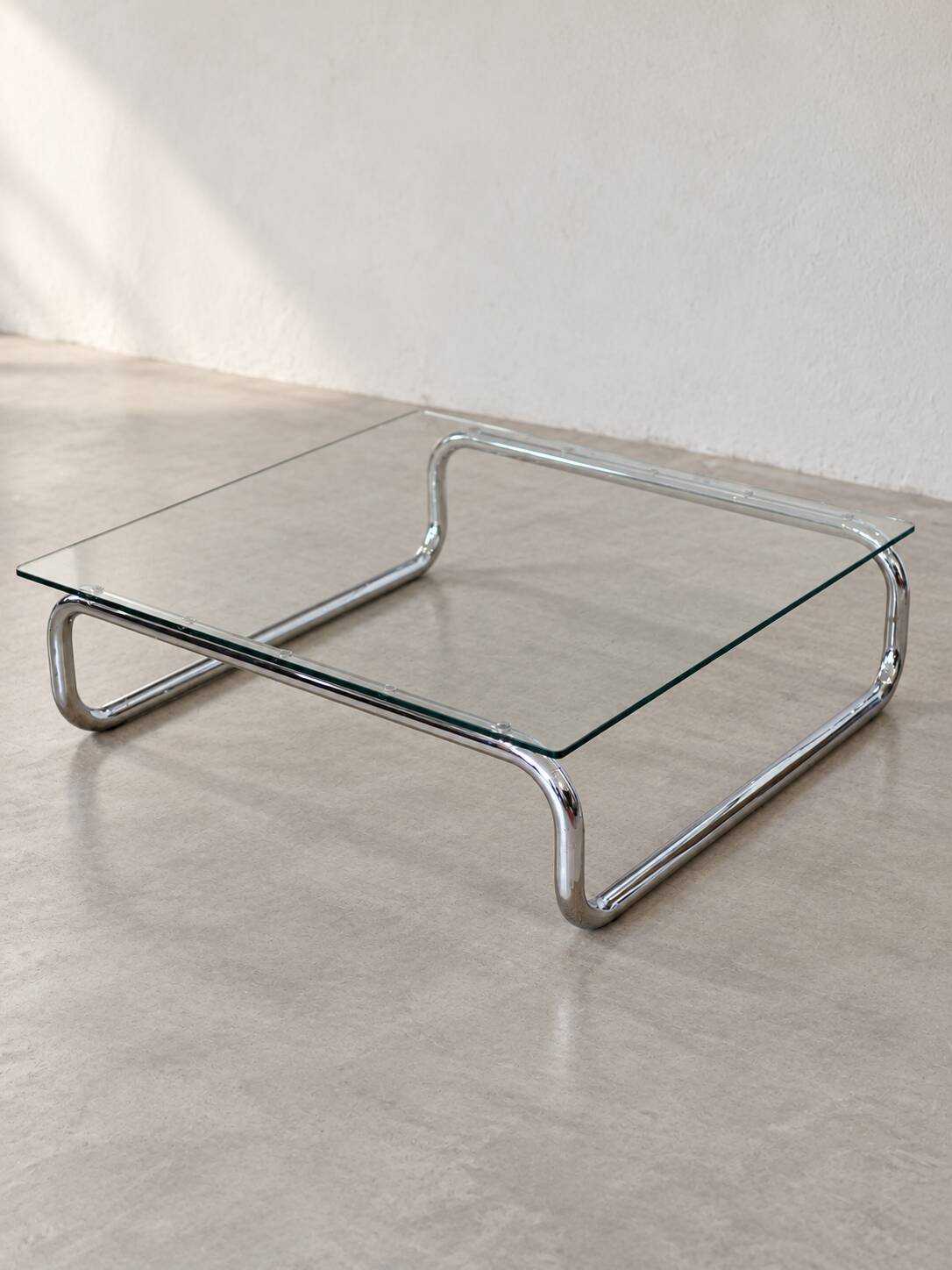 Coffee table in chrome with a glass top.