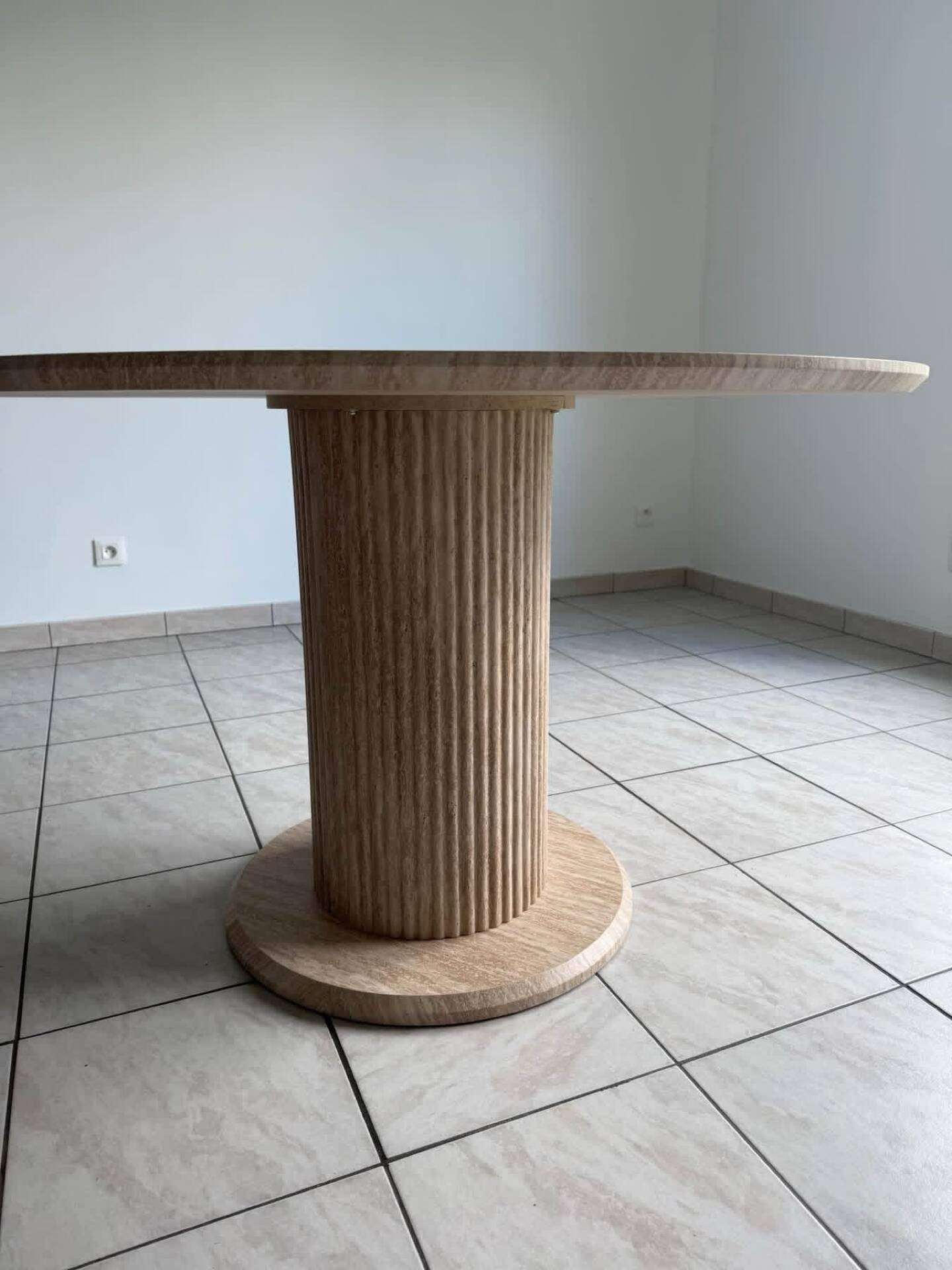 Round table with a travertine effect.