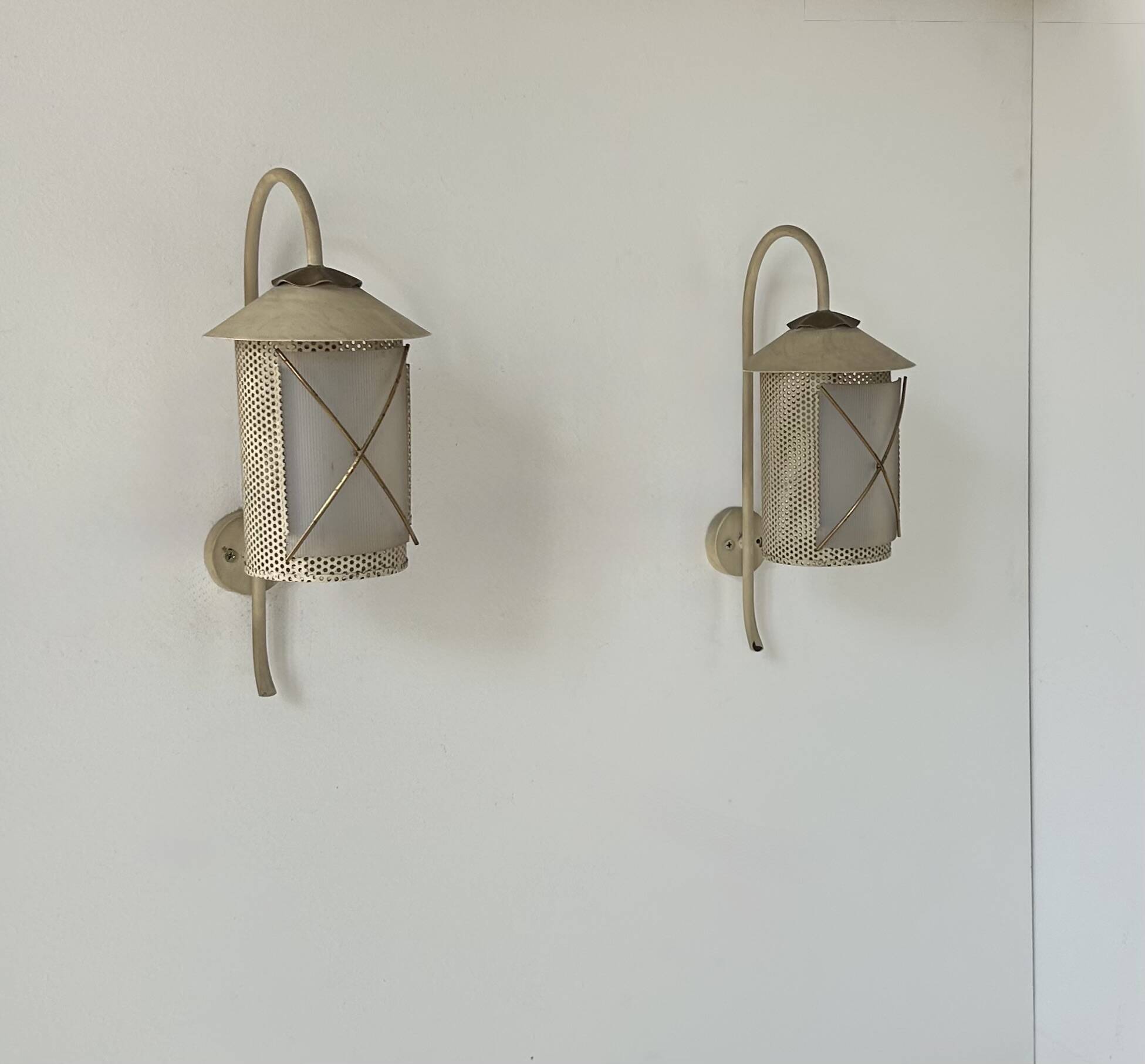 Pair of vintage wall lights in perforated metal, brass, and perspex, France, 1950.