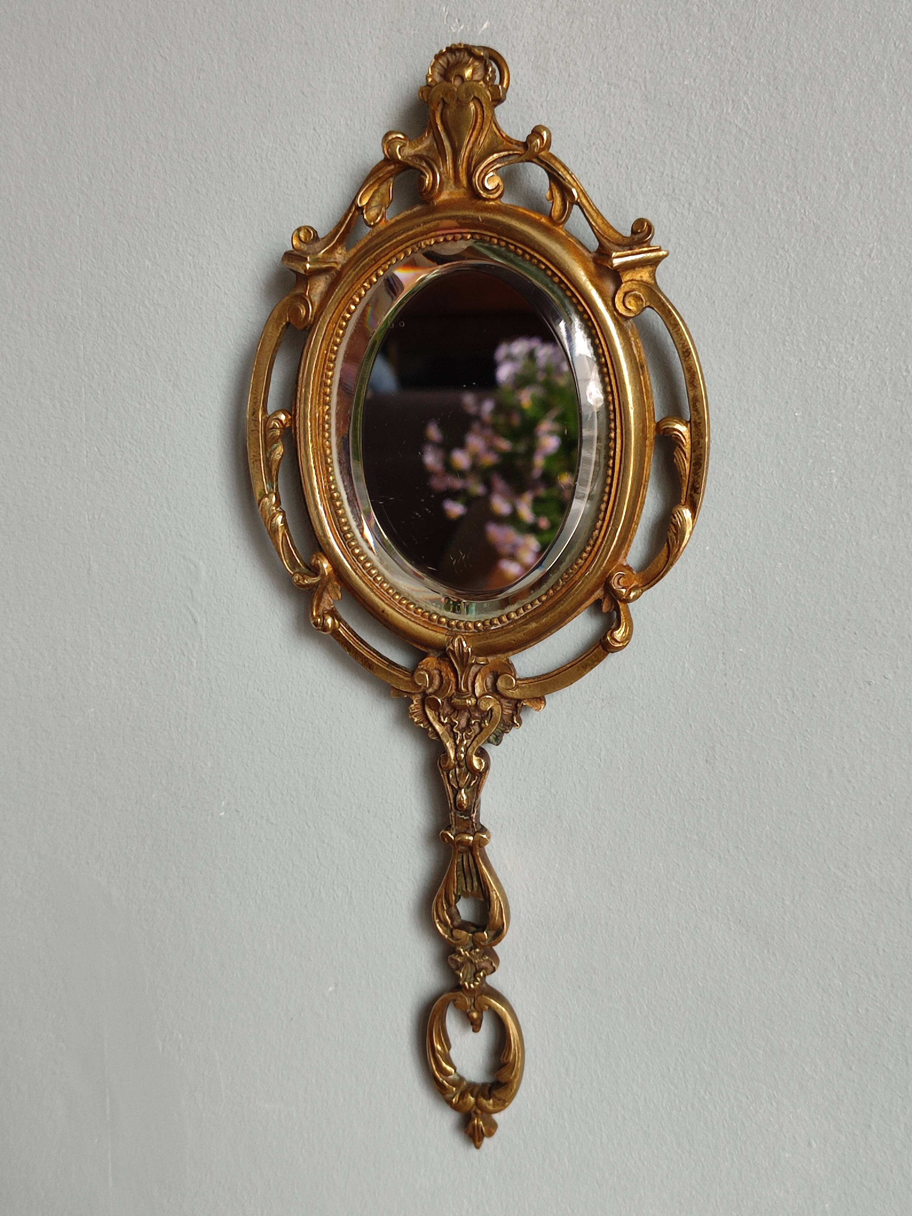 Antique hand-facing mirror in bronze and beveled glass