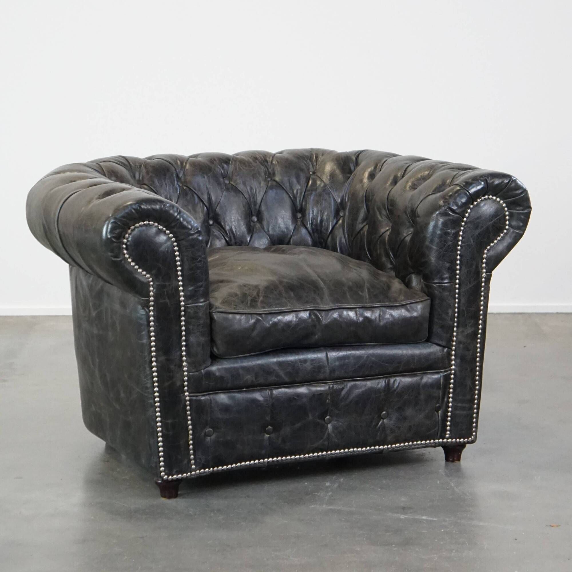 Spacious black cow leather chesterfield armchair with distinctive character