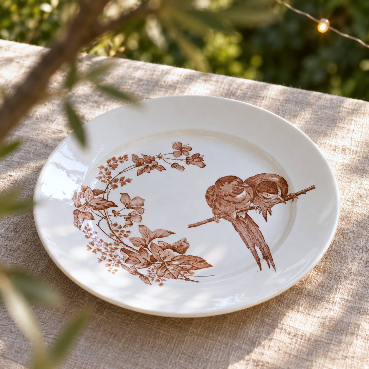 Large round dish from around 1870 signed Longwy with birds in sepia ironstone.