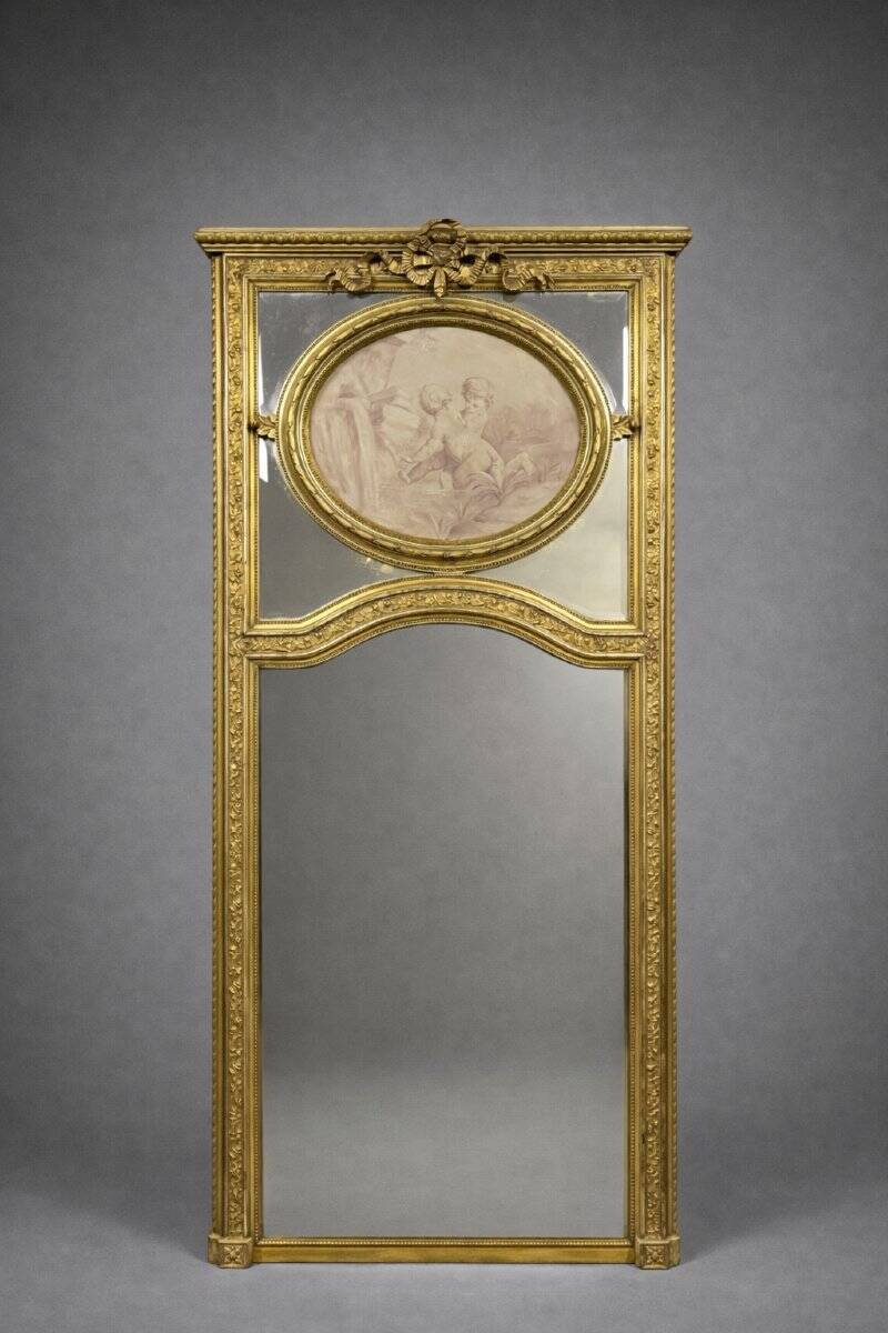 Very large mirror with mouldings, richly carved and gilded, in the Louis XVI style.