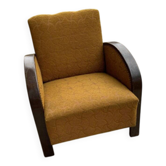 Art Deco armchair from the 1920s in straw yellow fabric and dark wood, with curved armrests.