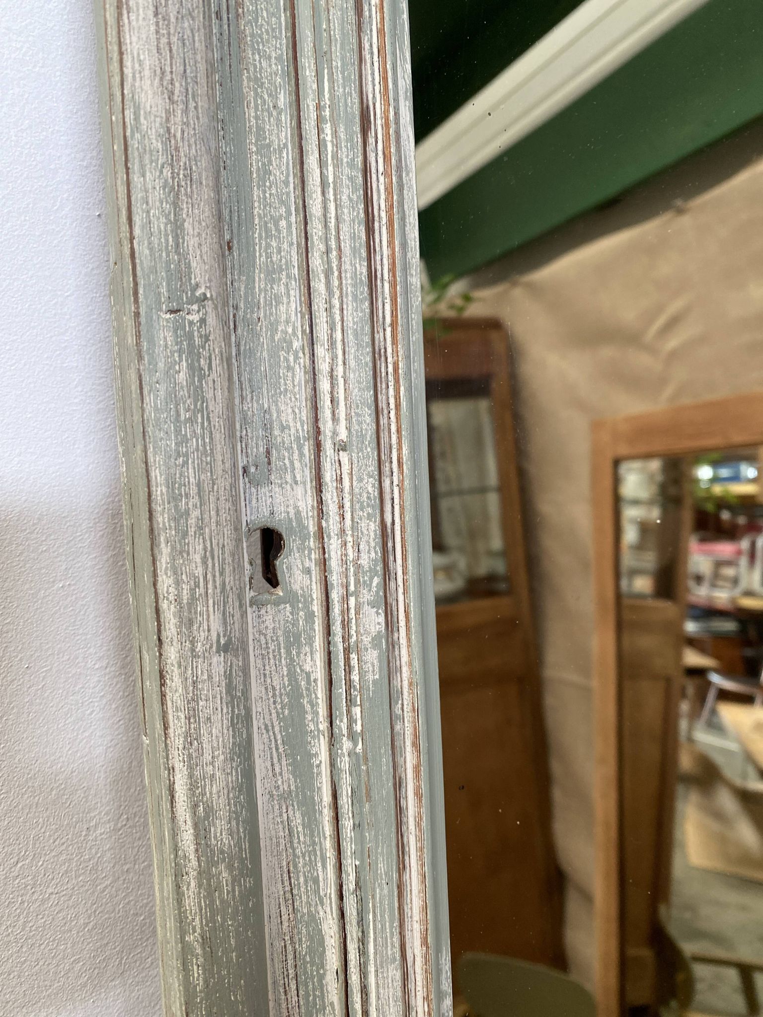 Antique mirror with a green and white patina.