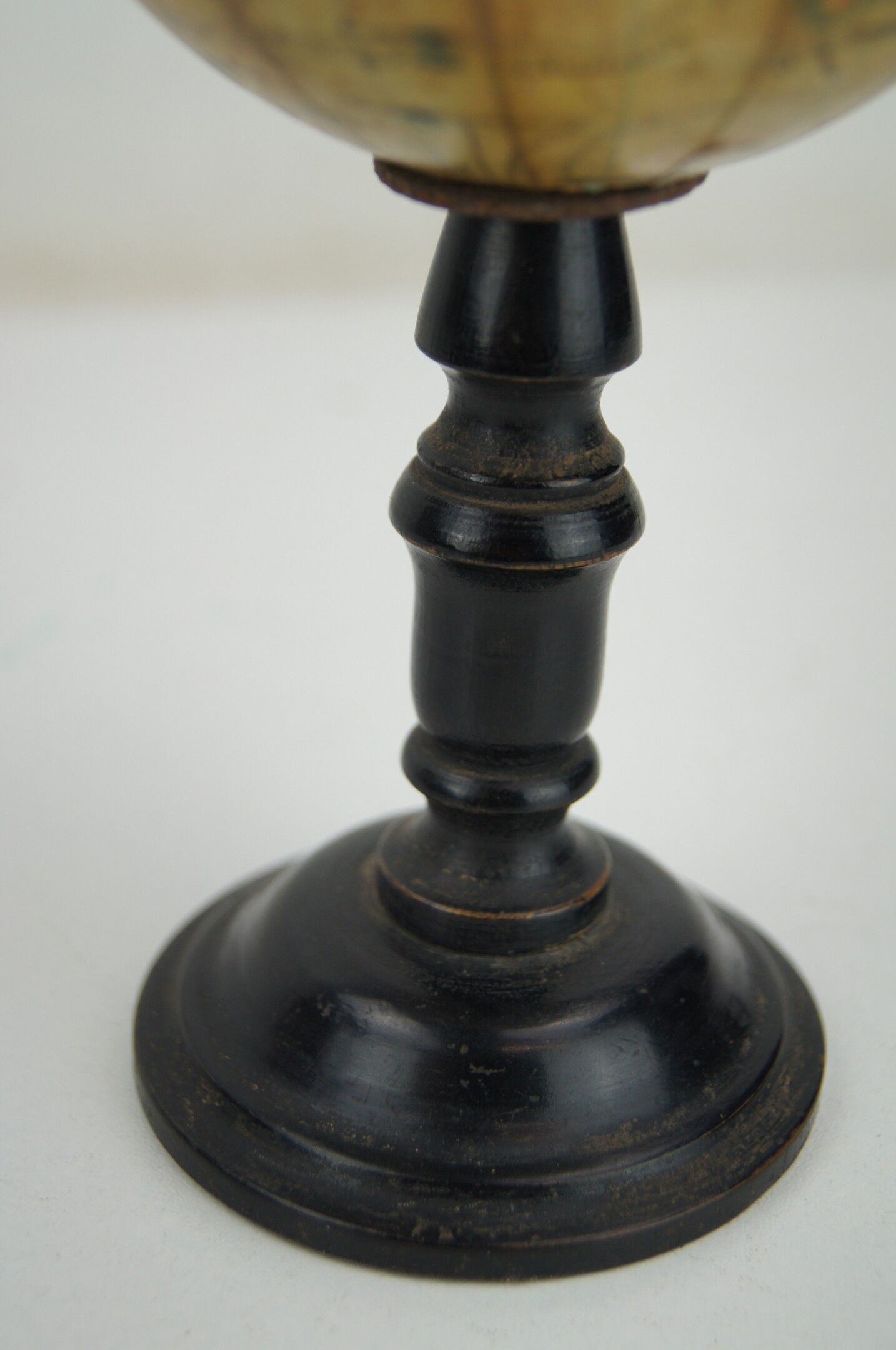 Globe on turned and blackened wooden base