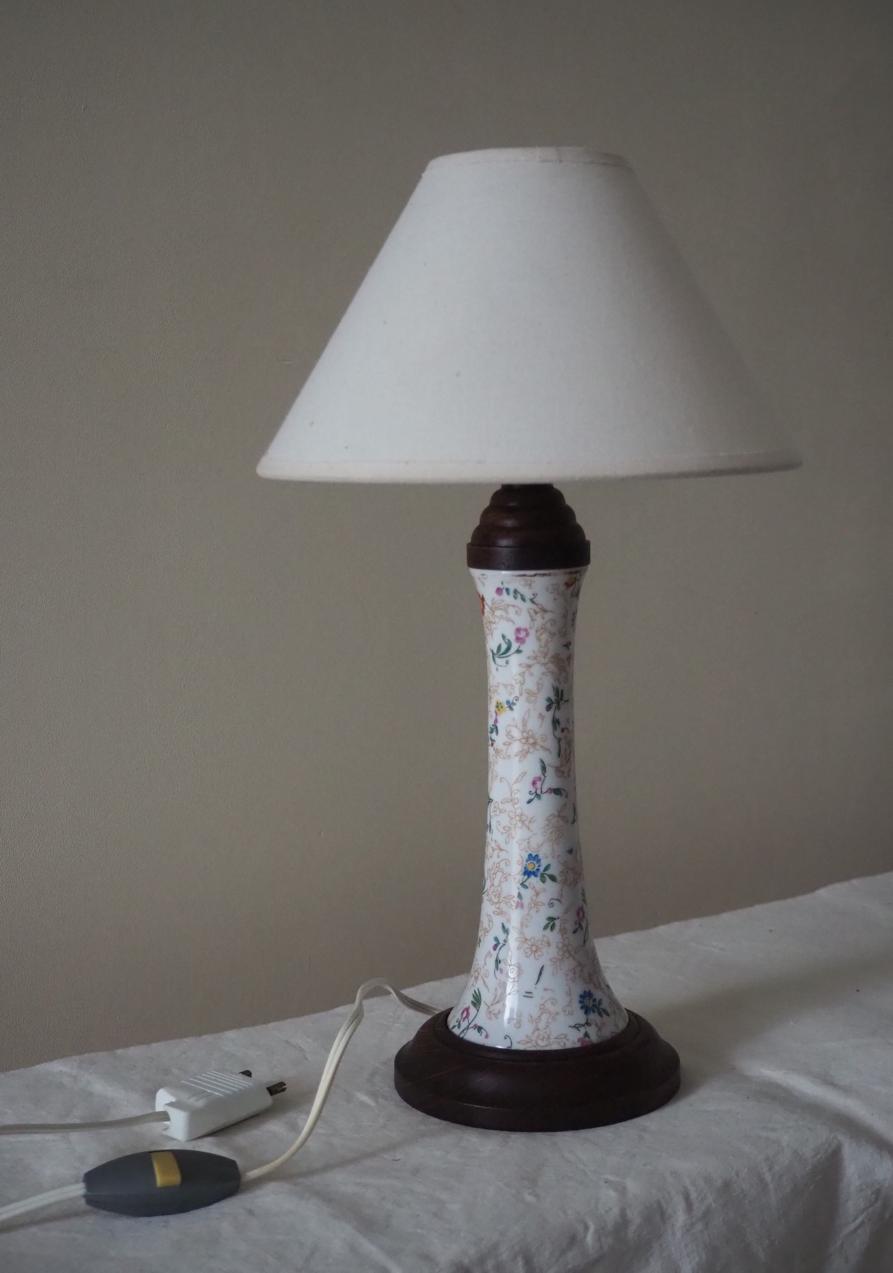 Table lamp for bedside use in earthenware with a wooden base.