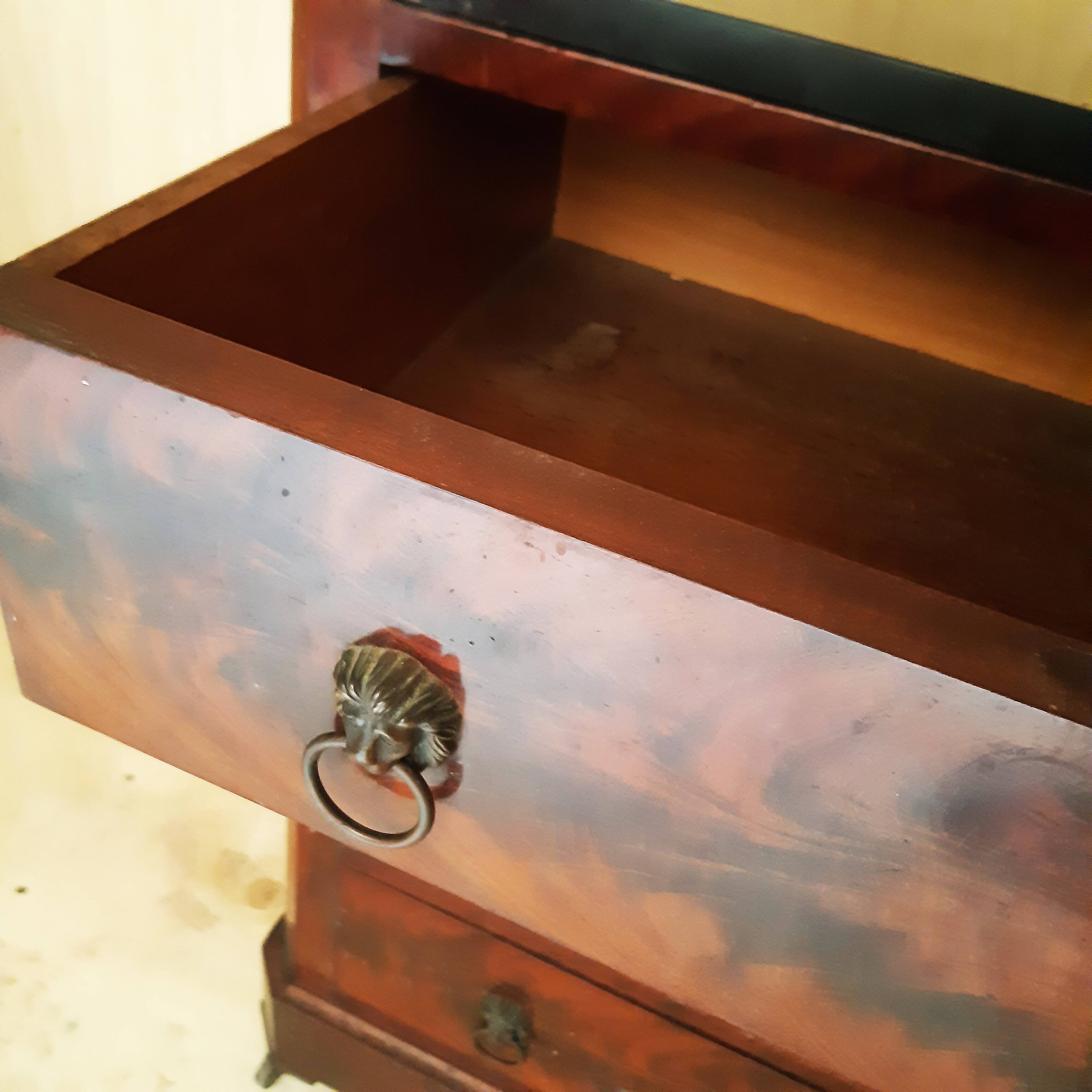 Antique chest of drawers with mahogany veneer and lion heads