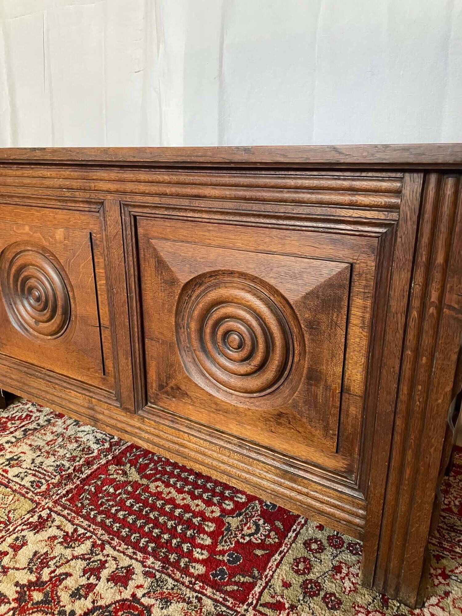 Small antique oak chest with carved panels.
