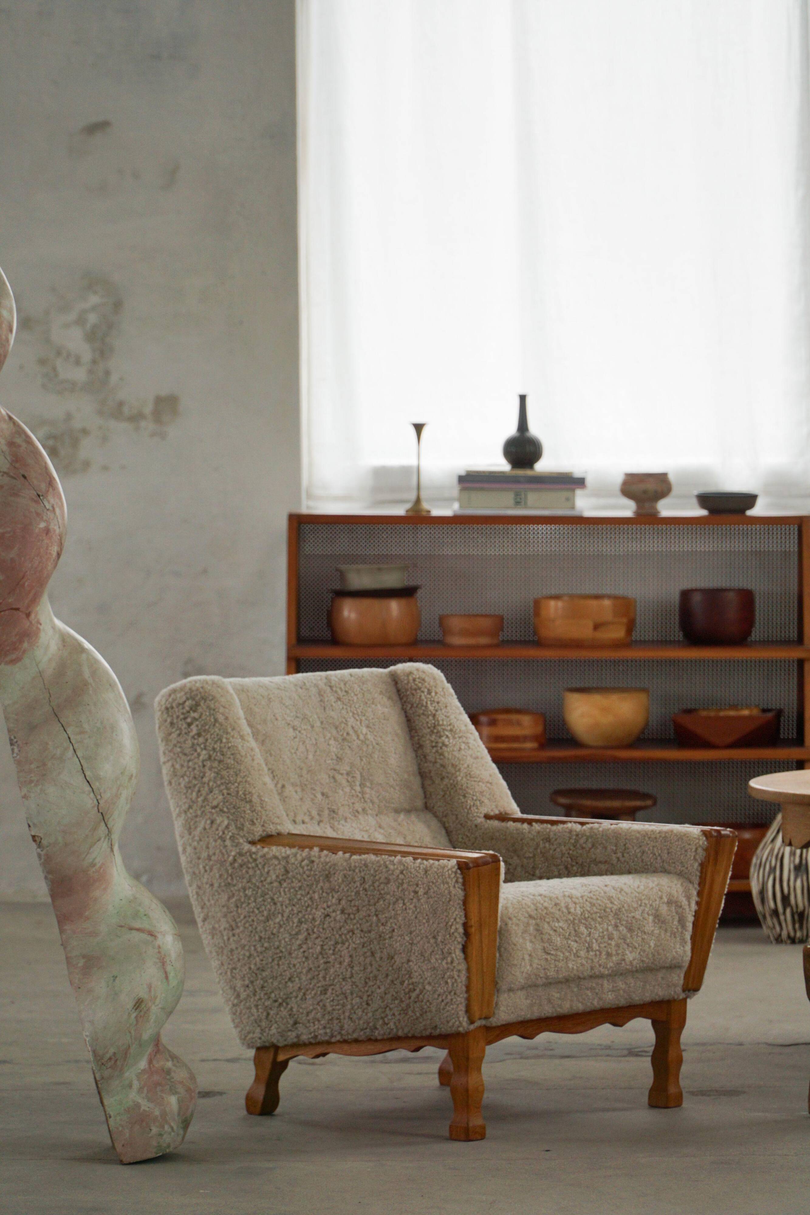 Modern Danish, a pair of easy chairs in oak and lamb's wool, Henning Kjærnulf, 1960s.