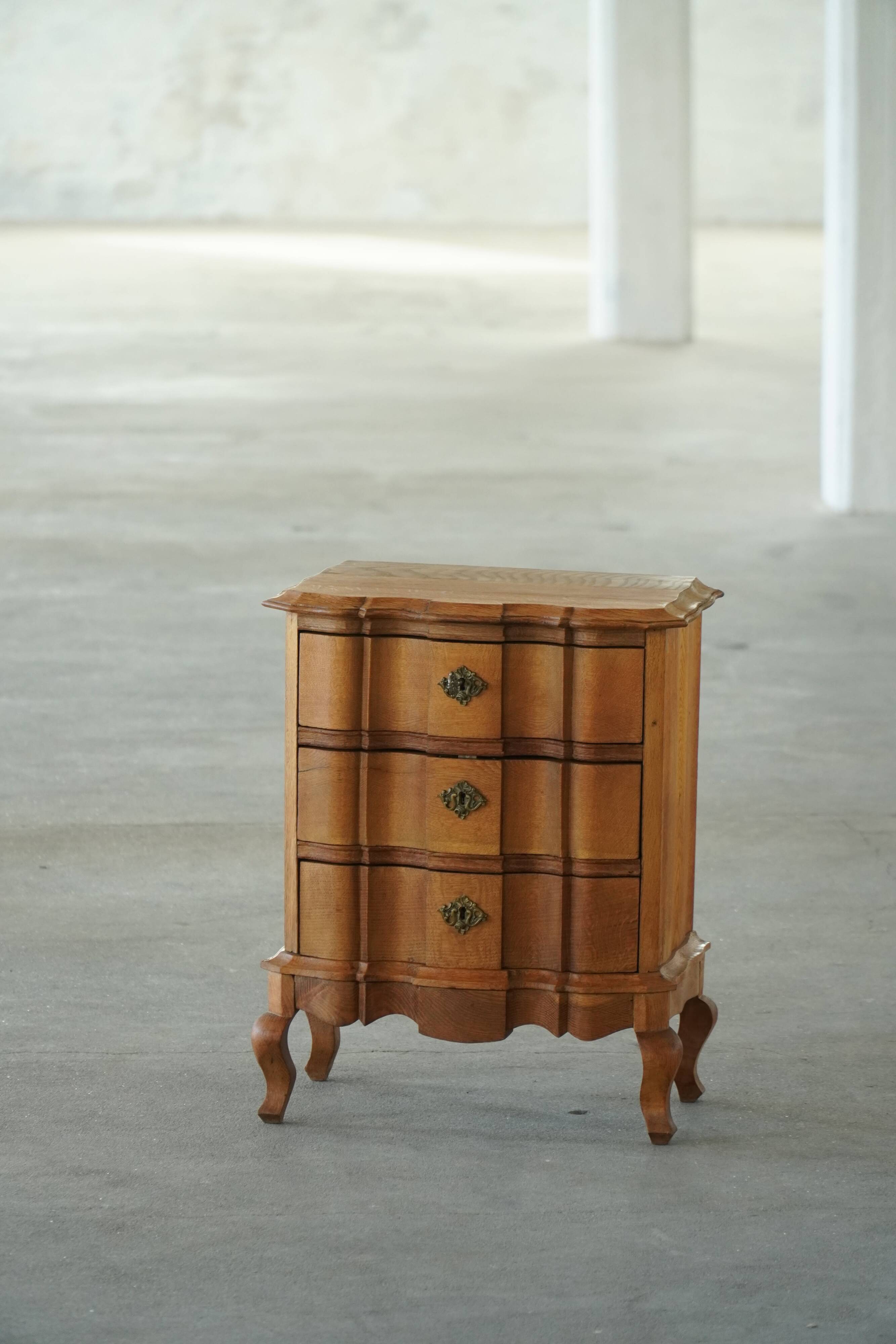 Danish neo-baroque oak commode with three drawers, featuring brass fittings, 1940s.