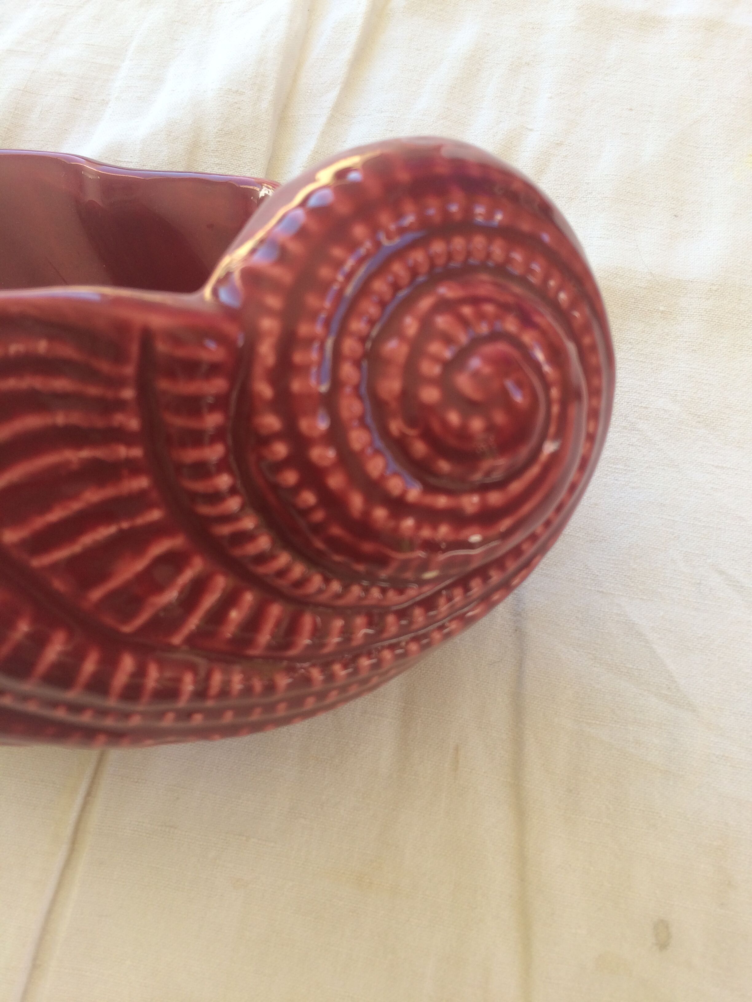 Empty red ceramic snail shaped pouch